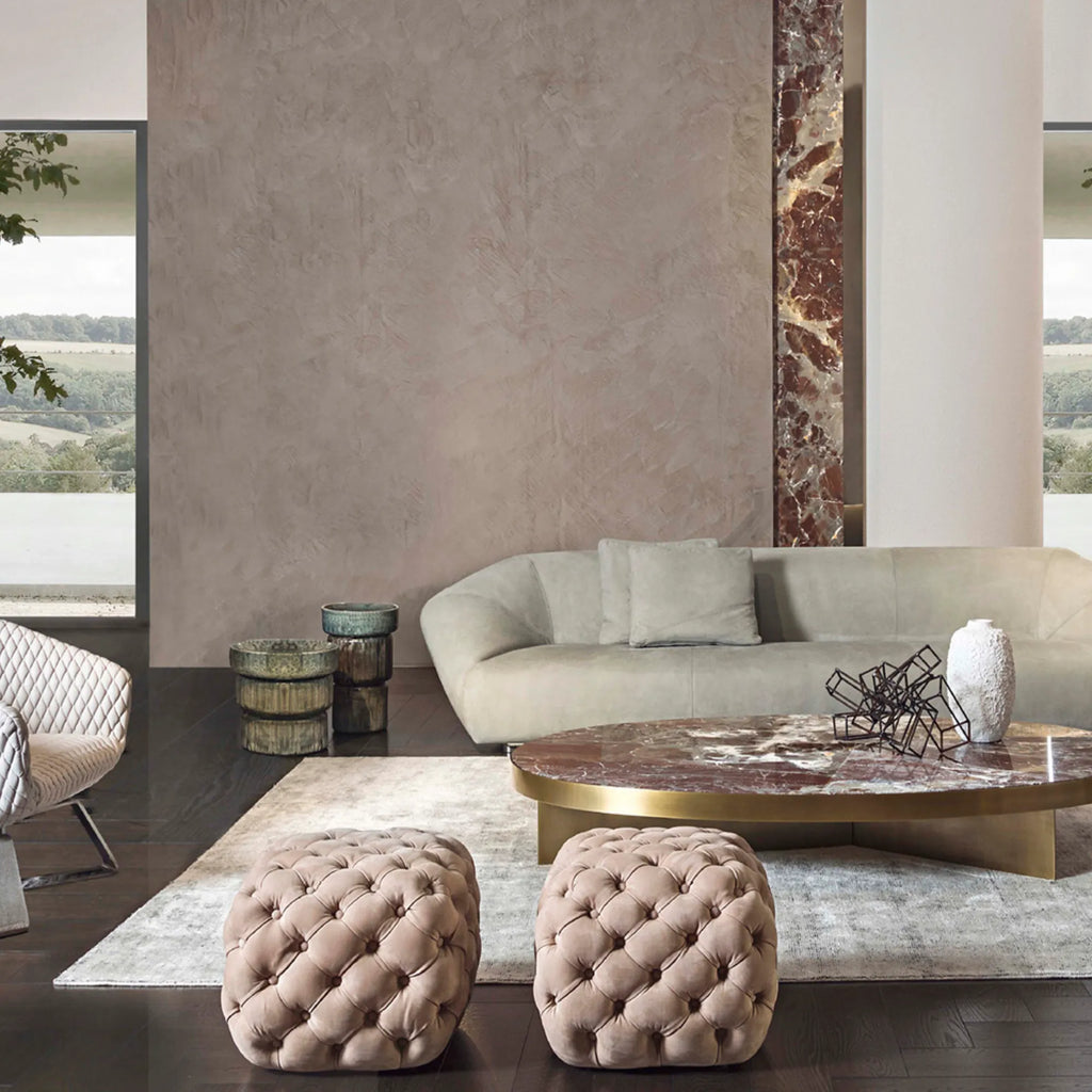 Hessentia Turtle Pouf, a plush modern glamorous ottoman upholstered in soft blush velvet with deep button tufting and a low, rounded square profile. This luxurious accent seating piece brings contemporary elegance and rich texture to any living room, bedroom, or lounge area.