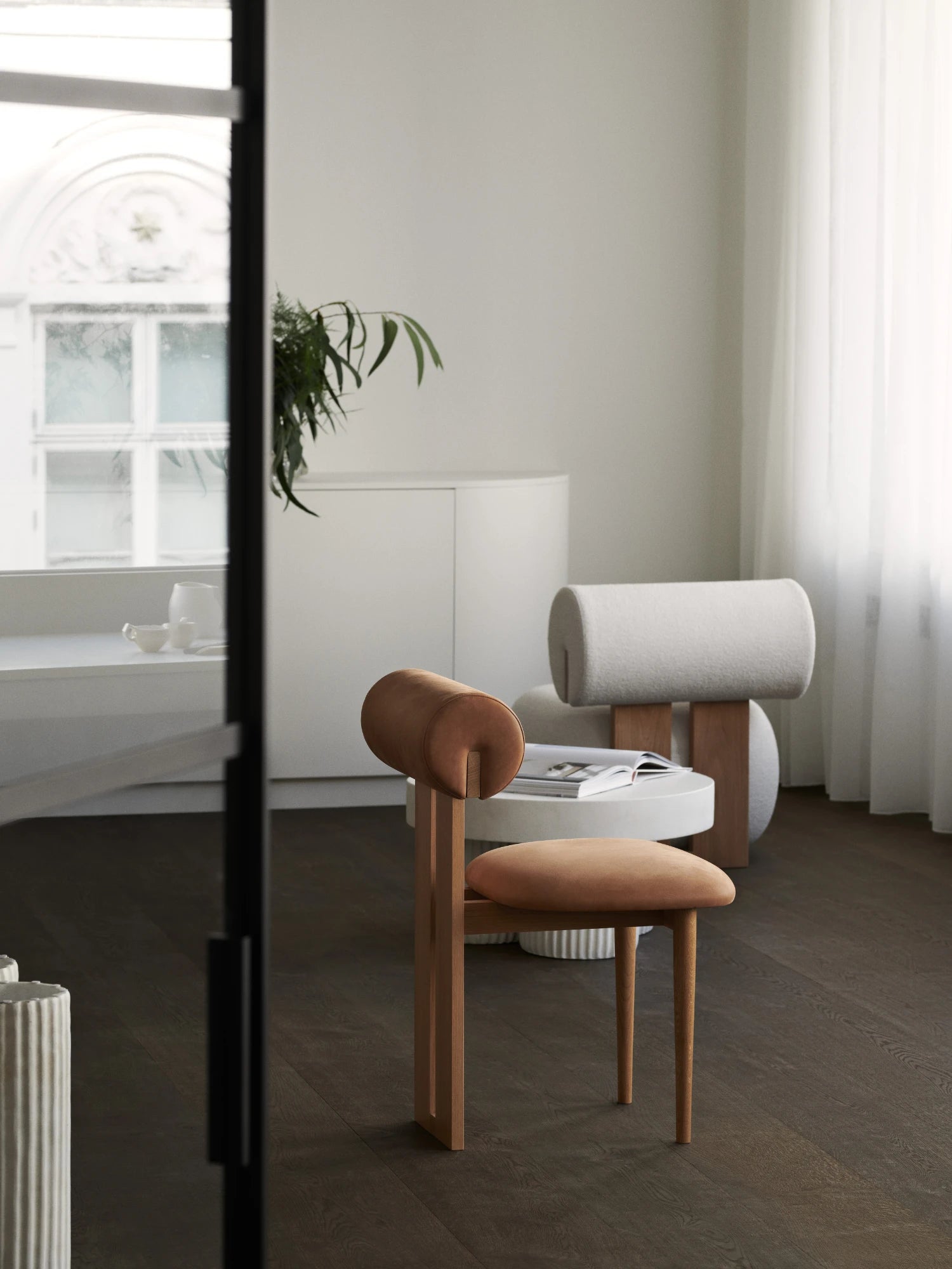 NORR11 Hippo Chair, a striking organic modern dining chair crafted from light natural oak wood, featuring a distinctive cylindrical backrest and rounded seat upholstered in a warm terracotta-toned fabric. This sculptural minimalist chair, with its sleek tapered legs, is perfect as a contemporary accent chair for living rooms or a stylish addition to modern dining spaces.