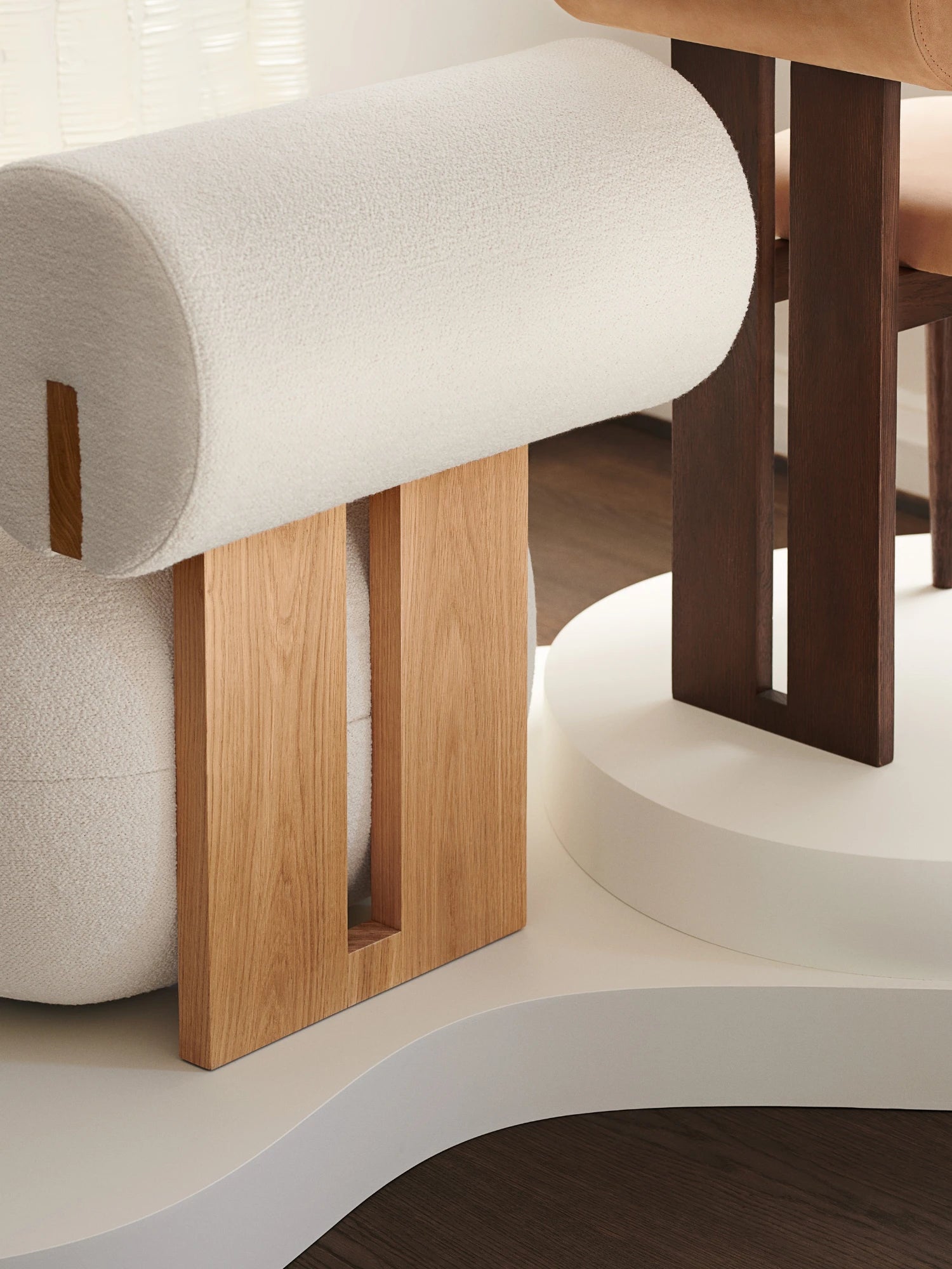 NORR11 Hippo Chair, a sculptural organic modern lounge chair featuring a thick, rounded armrest and backrest upholstered in textured cream bouclé fabric, supported by a substantial solid natural oak wood frame with.