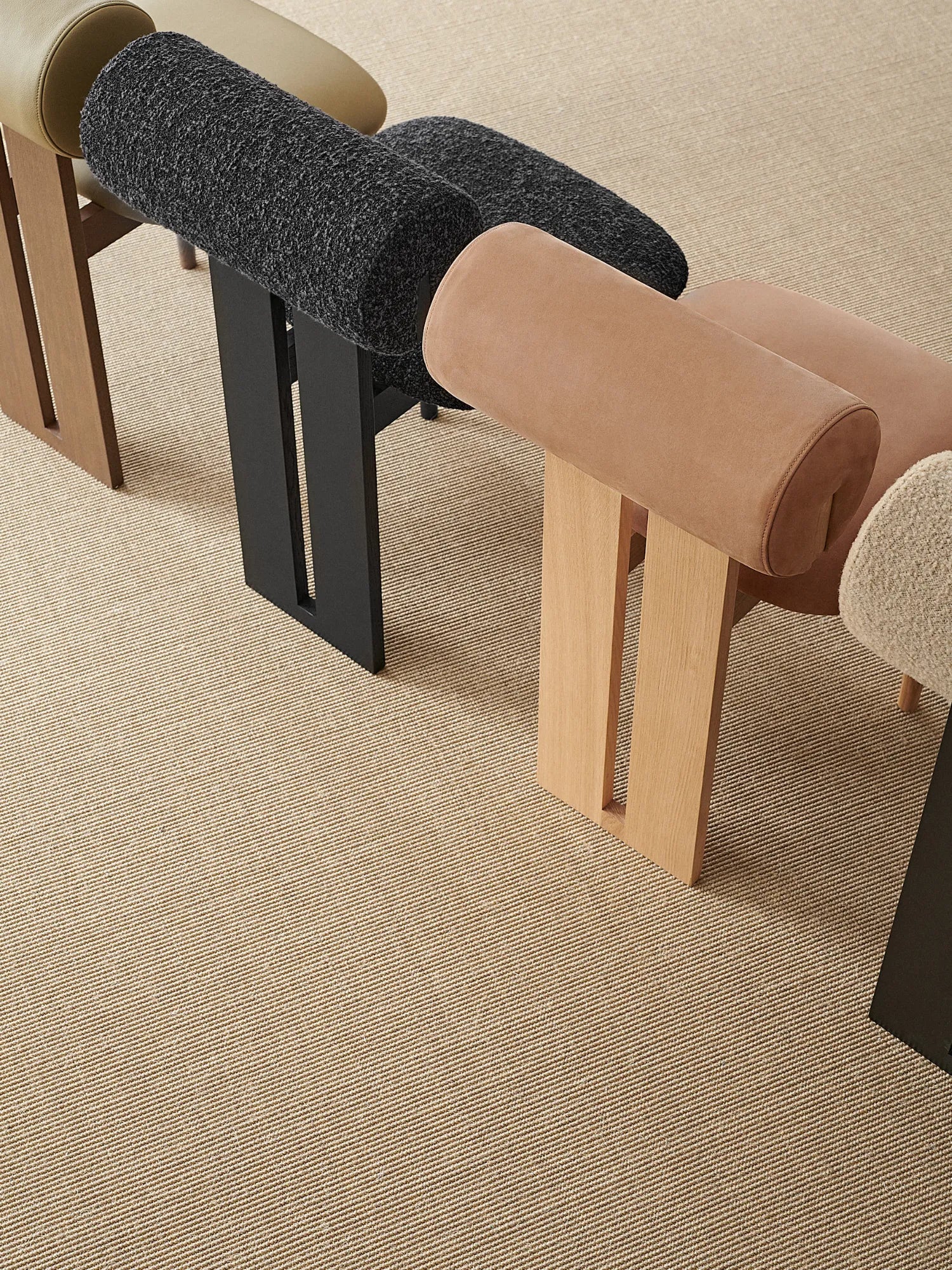 NORR11 Hippo Chair, a sculptural organic modern accent and dining chair featuring a distinctive cylindrical backrest and a gently curved seat, available in premium smooth leather or textured bouclé fabric upholstery.