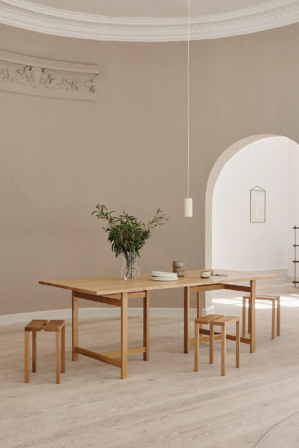 MOEBE Peg Stool, a minimalist Scandinavian solid oak stool featuring a distinctive split seat design and four tapered natural wood legs, showcasing clean lines and a smooth light oak finish. This versatile functional design stool is perfect for extra seating in a contemporary living room, a bedside table in a minimalist bedroom, or an entryway accent.