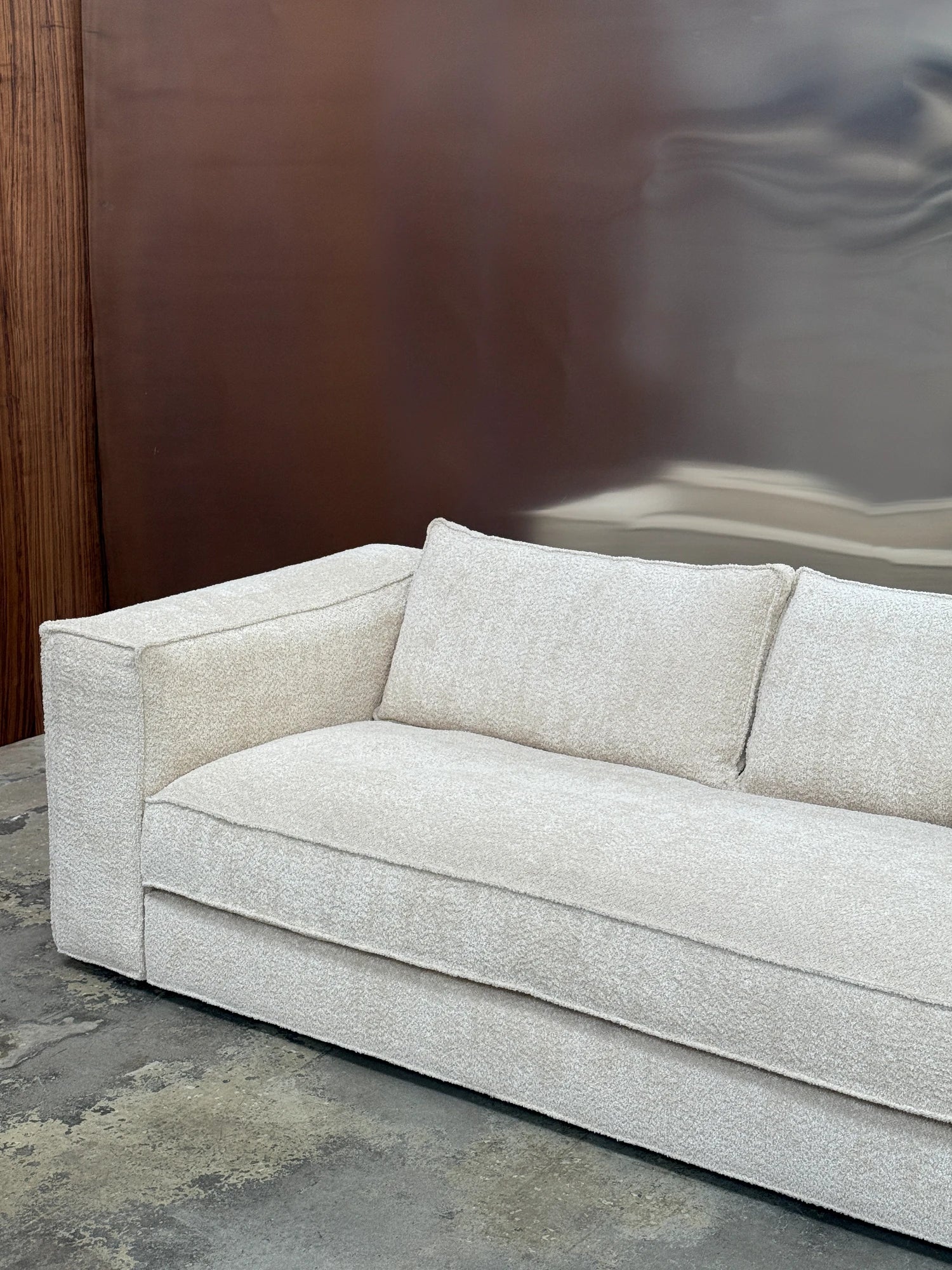 Tinted Objects Klinge Sofa, a sophisticated modern sofa upholstered in a luxurious cream bouclé fabric with a plush, textured weave and natural ivory tones.