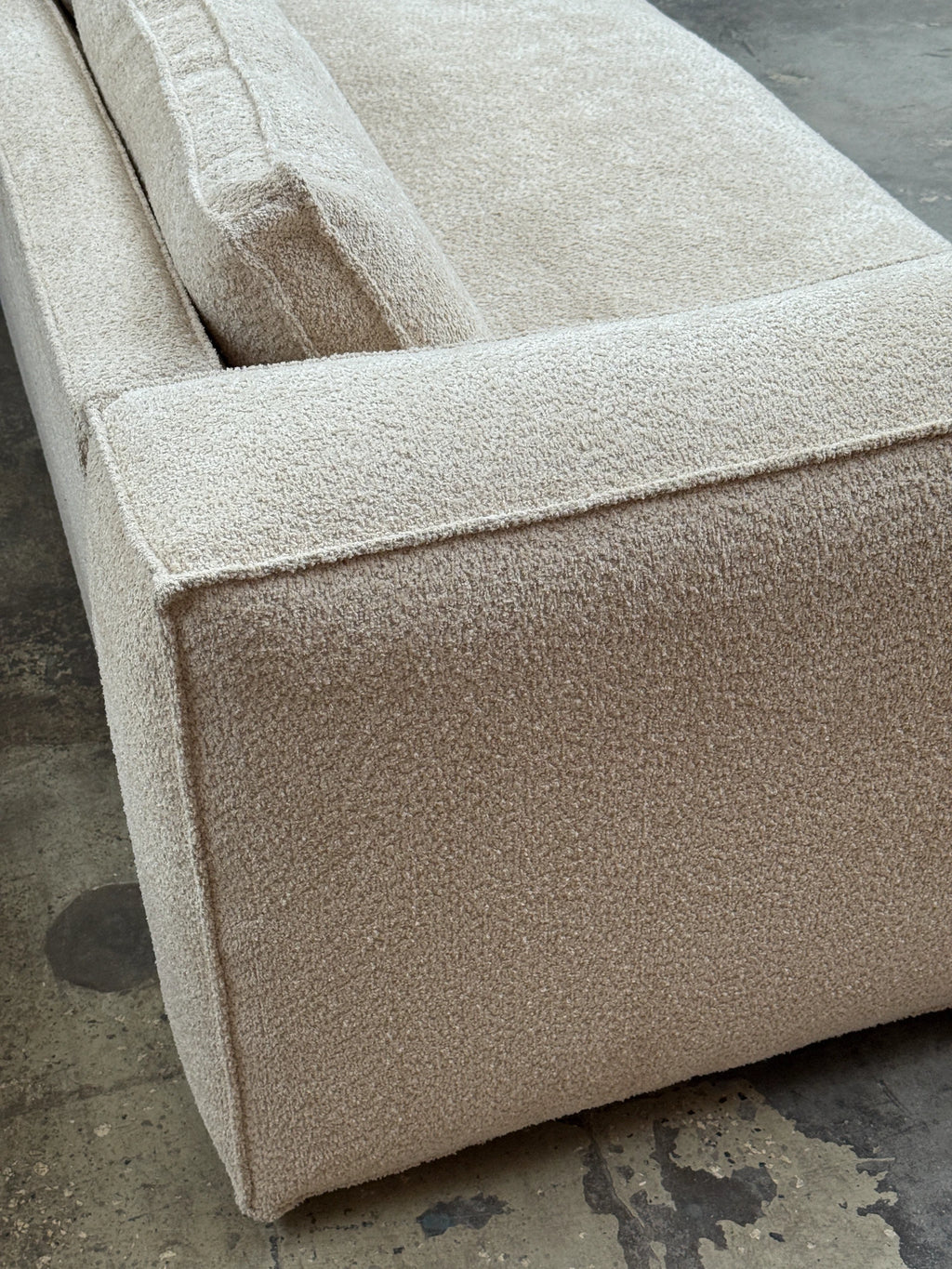 Tinted Objects Klinge Sofa, a modern light beige bouclé fabric sofa with visible seam lines and plush cushions. This stylish and comfortable seating solution is perfect for contemporary living rooms and design-conscious homeowners.