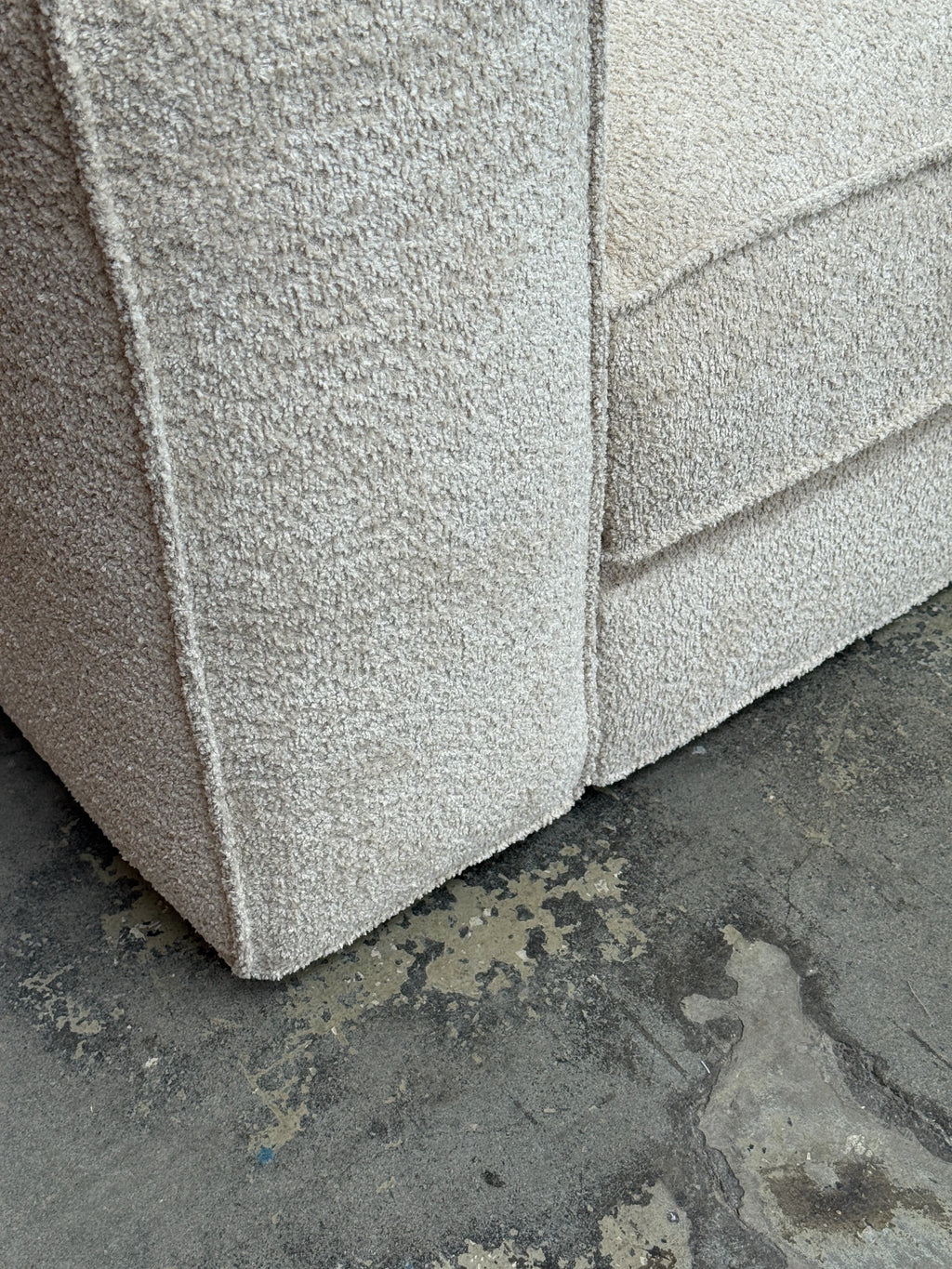 Tinted Objects Klinge Sofa, a modern light beige bouclé fabric sofa with a textured, cozy finish and visible piping details. This stylish and comfortable living room furniture is perfect for contemporary home decor enthusiasts.