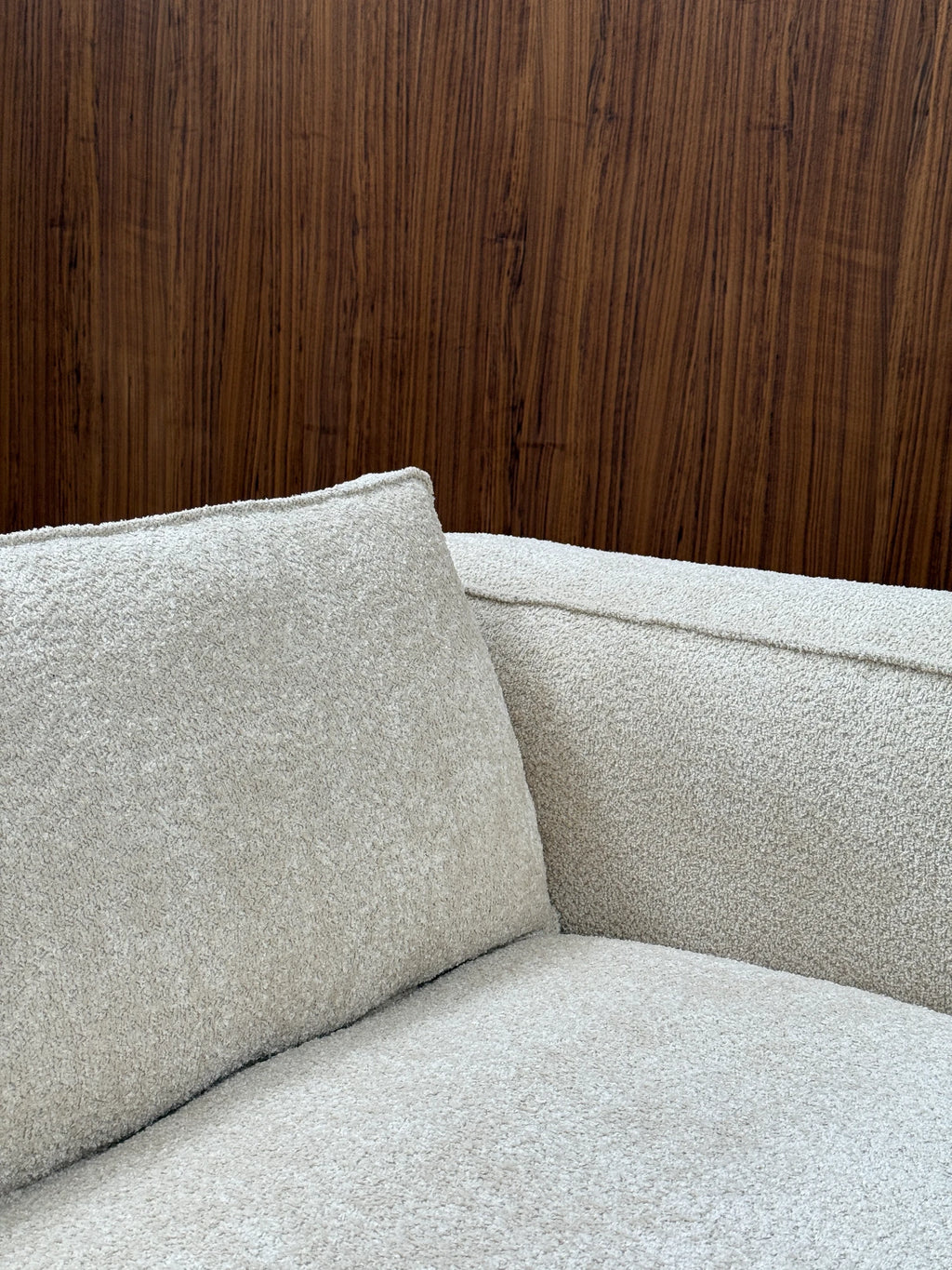 Tinted Objects Klinge Sofa, a modern designer sofa upholstered in luxurious light beige textured boucle fabric with clean piping details. This stylish and comfortable sofa is perfect for contemporary living spaces and discerning homeowners seeking elegant furniture.