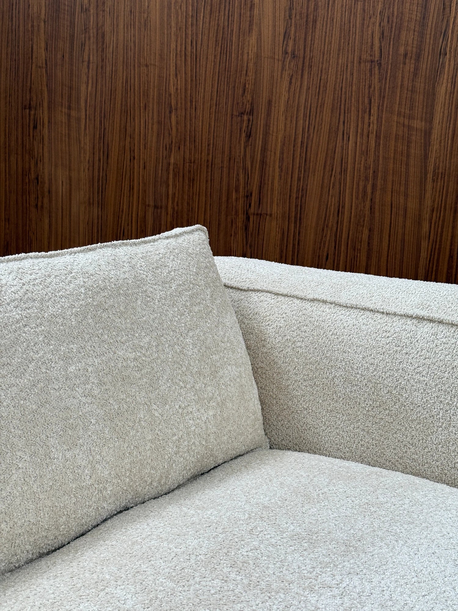 Tinted Objects Klinge Sofa, a modern designer sofa upholstered in luxurious light beige textured boucle fabric with clean piping details. This stylish and comfortable sofa is perfect for contemporary living spaces and discerning homeowners seeking elegant furniture.