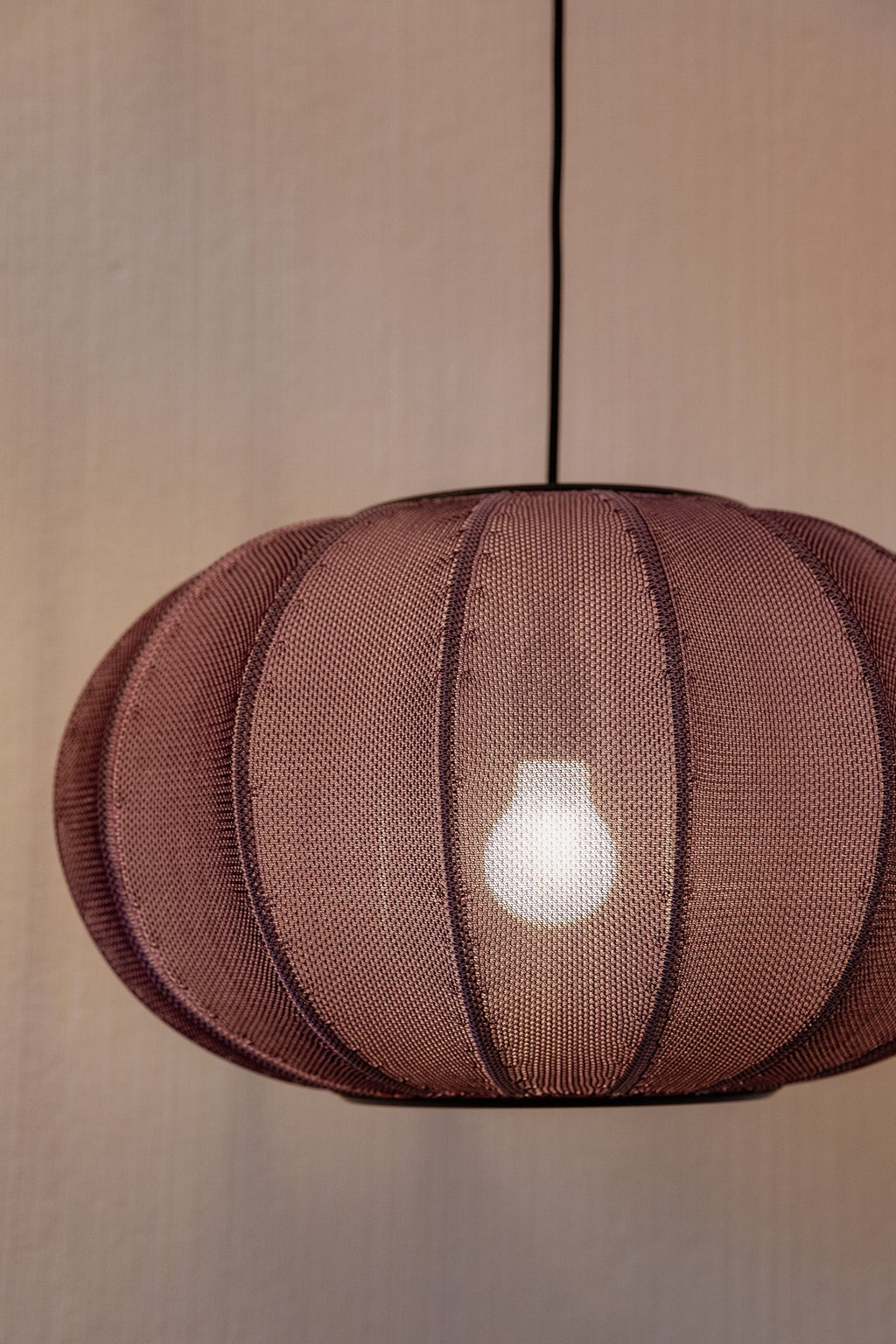 Made by Hand Knit-Wit Ø45 Oval Pendant Lamp, a distinctive modern minimalist pendant lamp featuring a soft dusty rose knitted polyester yarn shade with a unique ribbed, flattened oval silhouette.