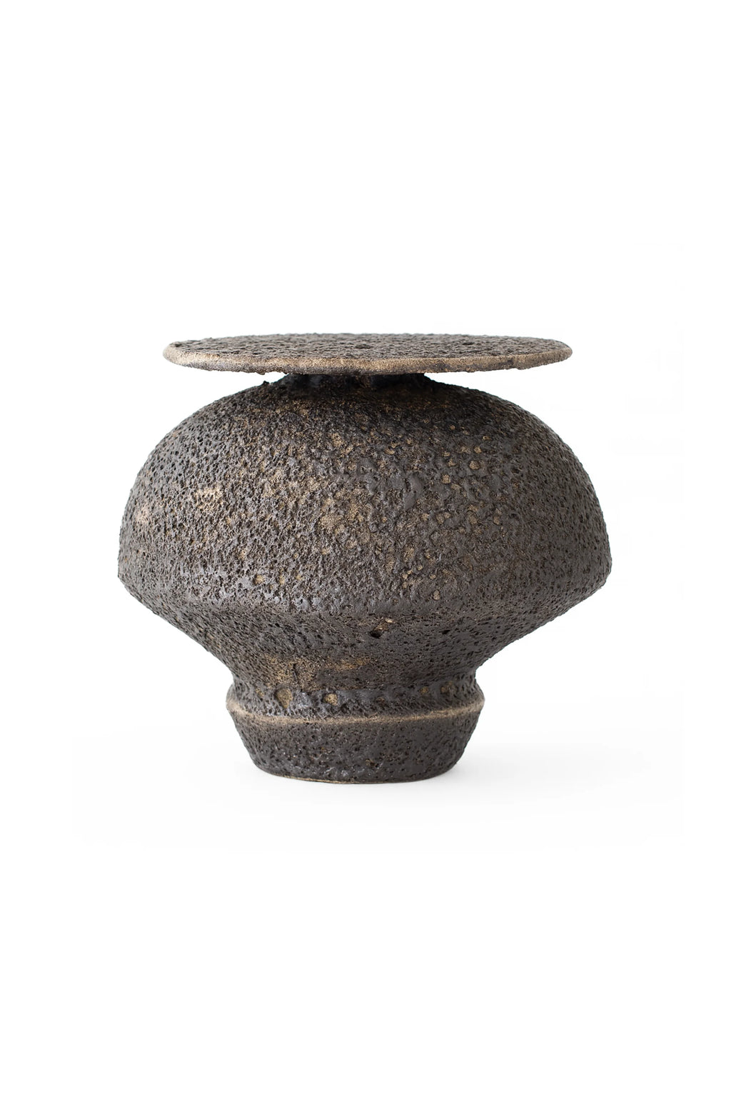 Canoa Lab Isolated n.18 Vase, a handcrafted ceramic vase with a deep earthy dark brown and charcoal black volcanic textured finish, featuring a unique globular body and a distinct flat, porous disc top. This sculptural stoneware piece embodies an organic modern and brutalist aesthetic, perfect for minimalist shelf styling or as a contemporary living room accent.