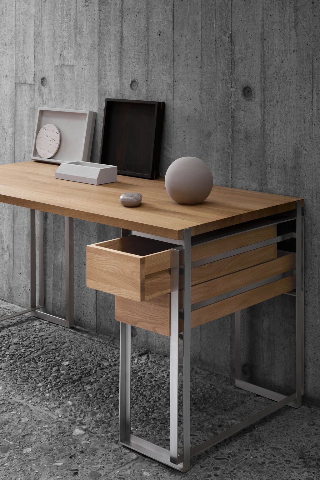 Kristina Dam Outline Desk, a modern minimalist writing desk featuring a natural solid oak desktop and integrated storage drawers, supported by a sleek matte stainless steel frame. This Scandinavian-inspired desk is perfect for a contemporary home office or design-conscious workspace.