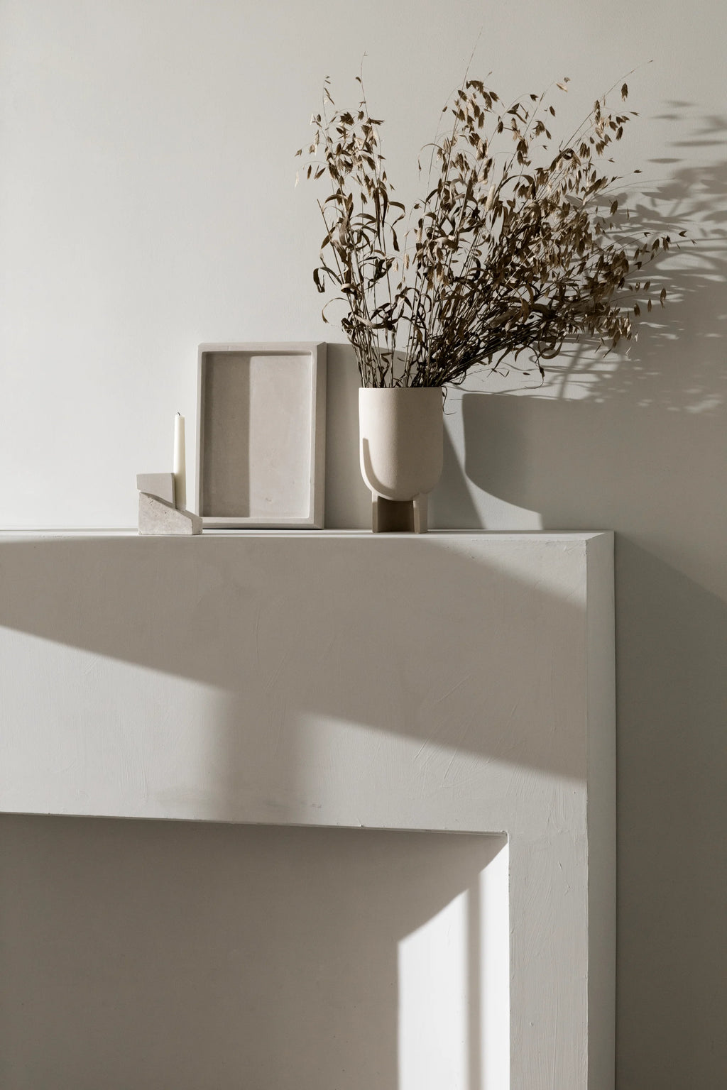 Kristina Dam Offset Candleholder Vol. 1, a modern minimalist taper candle holder crafted from solid light greige concrete. It features a striking geometric and brutalist-inspired sculptural design with an offset, layered block silhouette and a matte, textured finish. This architectural concrete decor piece is perfect for contemporary shelf styling in a living room, entryway, or home office.