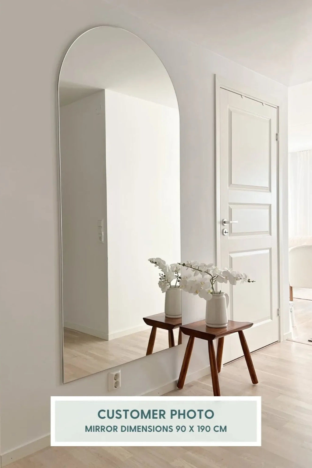 TCL Studios Arc Full Length Mirror, a sleek modern minimalist full-length mirror featuring a distinctive arch-top design and a clean frameless edge, offering a contemporary and expansive reflection. This large arch mirror, measuring 90 x 190 cm, creates an illusion of space with its elegant silhouette. Ideal as a stylish floor mirror or wall mirror for Scandinavian bedrooms, modern living rooms, or minimalist entryways.