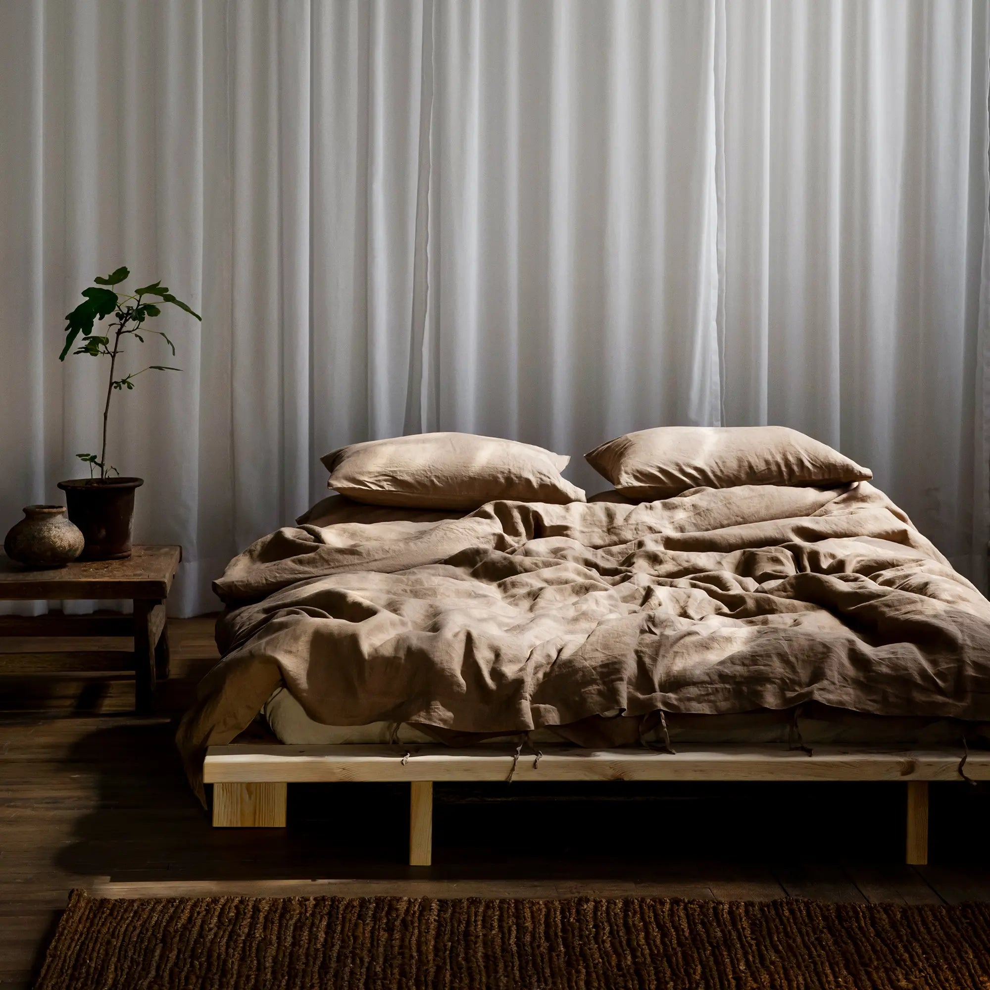 Handcrafted solid wood platform bed with minimalist design and clean lines, inspired by traditional Japanese architecture, in its natural state without any finish or staining, perfect for creating a peaceful and calming atmosphere in any bedroom