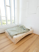 the orbit bed karup design in a minimalistic apartment that has tall white walls and big windows that bring alot of natural light into the room