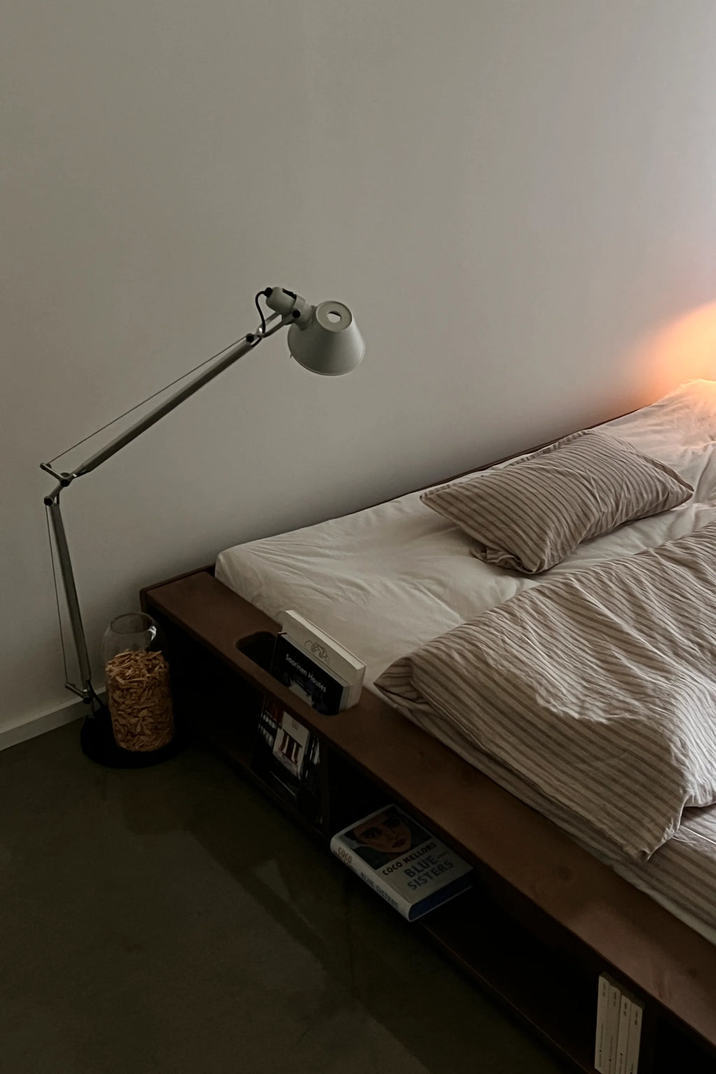 Bedroom with a bed, lamp, and small table.