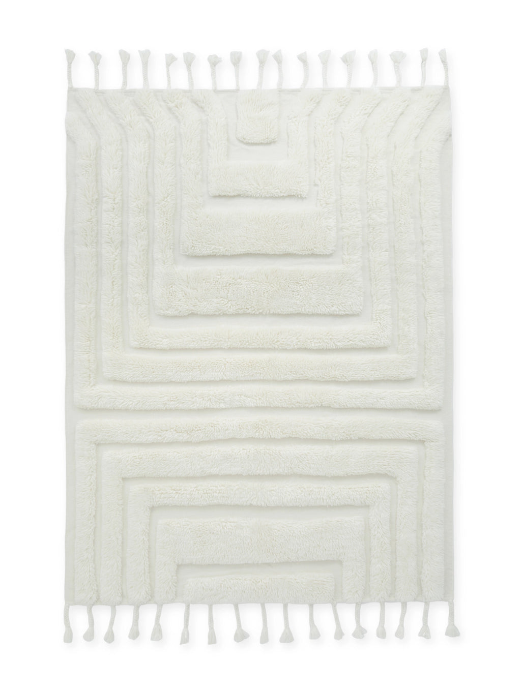 Tinted Objects Kask Wool Rug, a plush off-white woven area rug featuring an abstract geometric pattern with raised shaggy textures and decorative tassels on both ends. This luxurious soft wool rug adds warmth and contemporary style to any living room or bedroom.