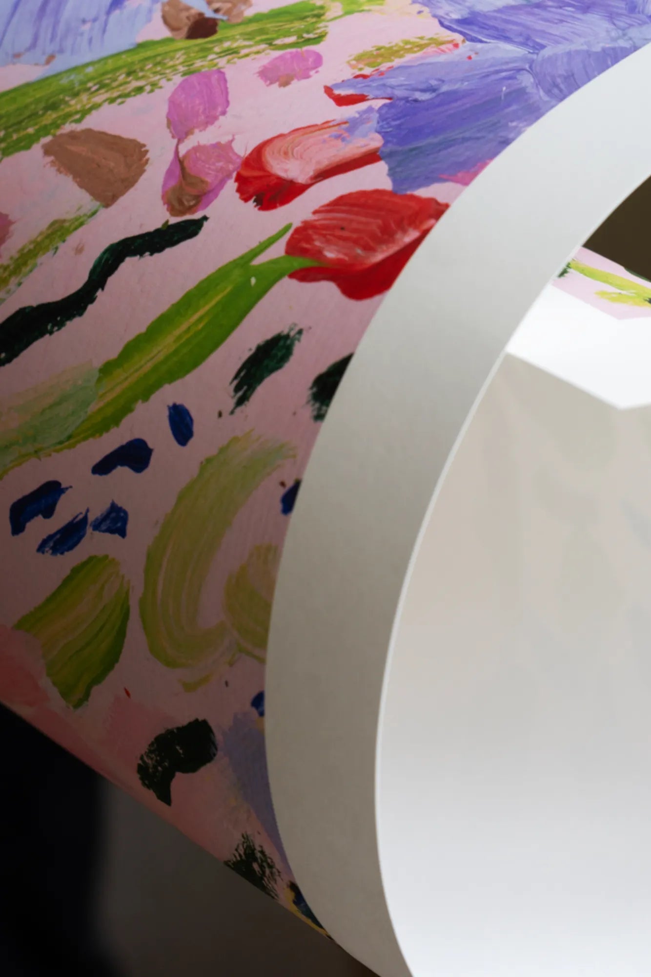 Close-up of a delicate pink and purple flower in a field of vivid green grass