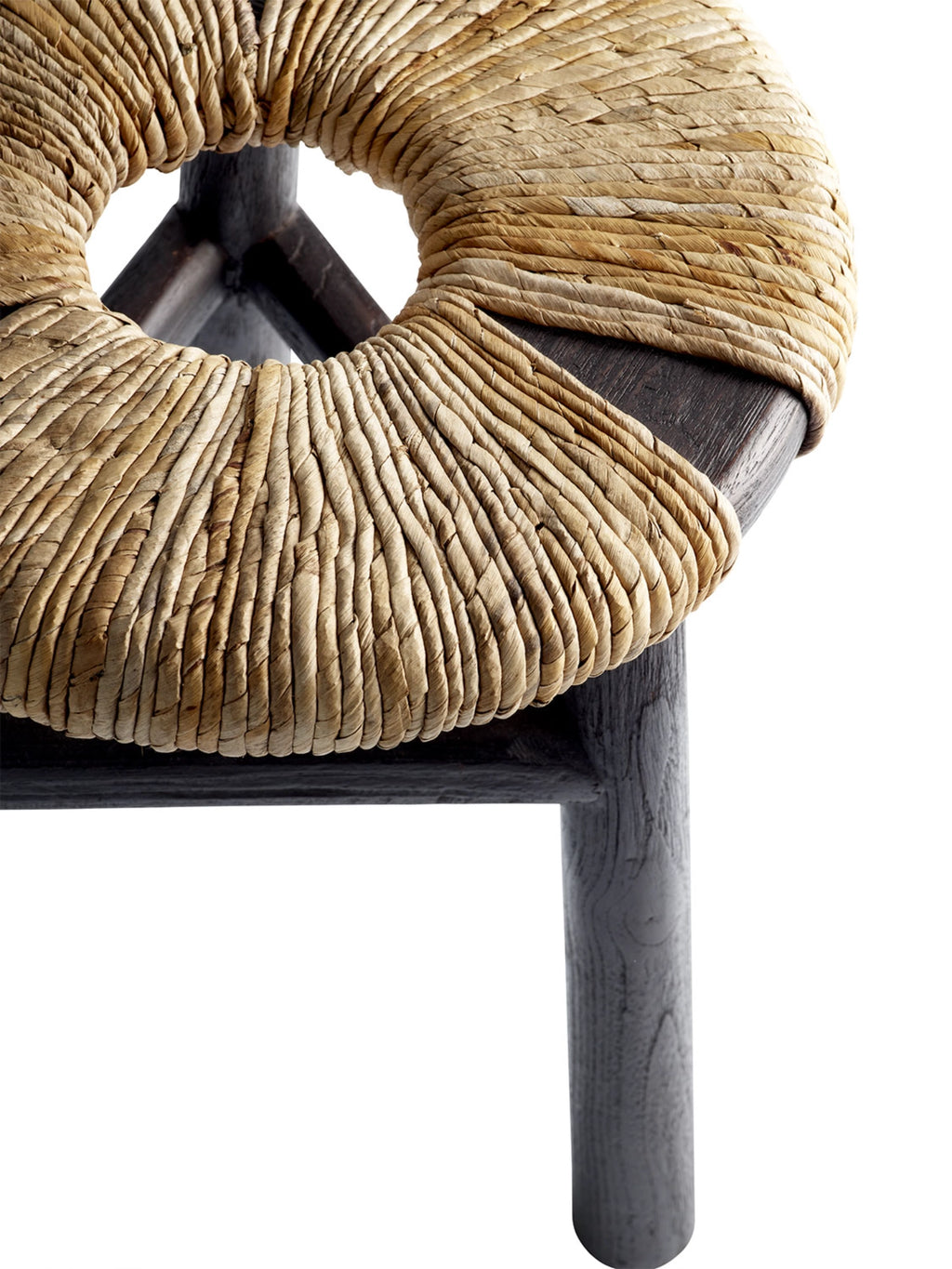 Tine K Kayu Stool, a rustic organic modern accent stool featuring a round, tightly woven natural straw seat with a central circular cutout, showcasing rich beige and light brown tones and a distinct textured finish. This natural fiber stool is supported by a sturdy dark solid wood frame with visible grain and cylindrical legs. Ideal as a versatile boho living room stool, bedroom accent, or unique entryway furniture.