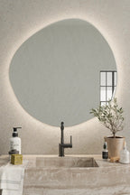 Pebble Mirror with Lights creating a warm and inviting atmosphere in cozy reading nook