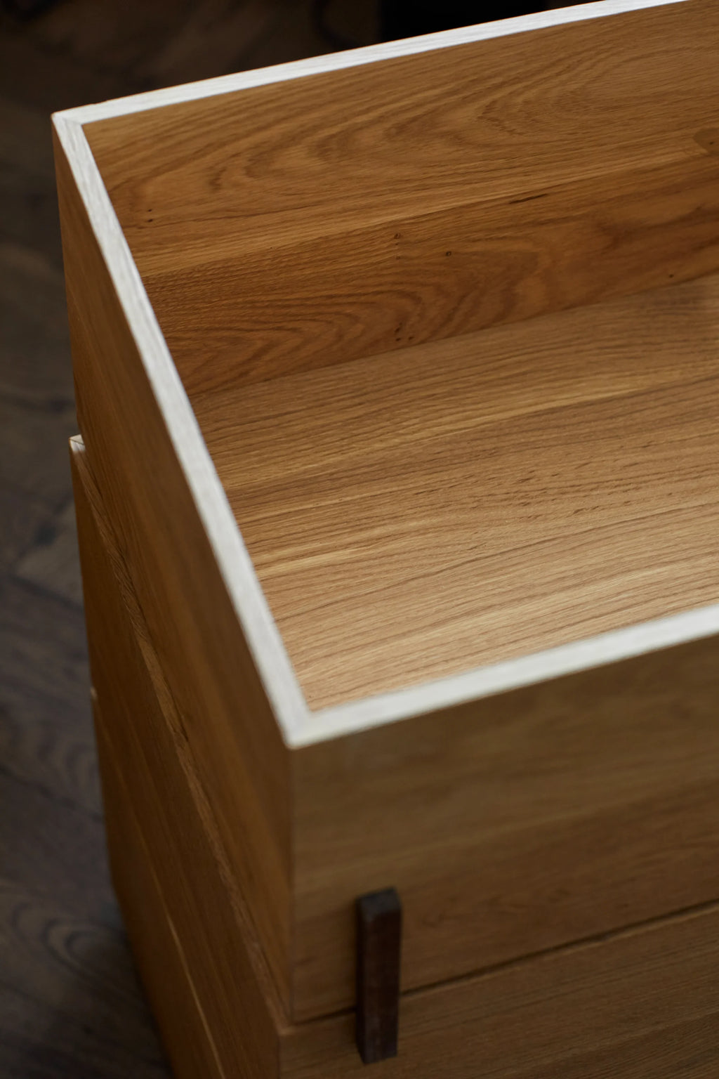 Kristina Dam Stack Storage Box - Set of 3, a modern minimalist storage solution crafted from light natural oak wood with distinctive pale contrasting edges and a subtle dark accent detail. This Scandinavian-inspired rectangular storage box features a smooth wood grain and an open-top design, perfect for organizing essentials or for chic shelf styling. Ideal for contemporary living rooms, home offices, or bedrooms seeking elegant natural wood storage.