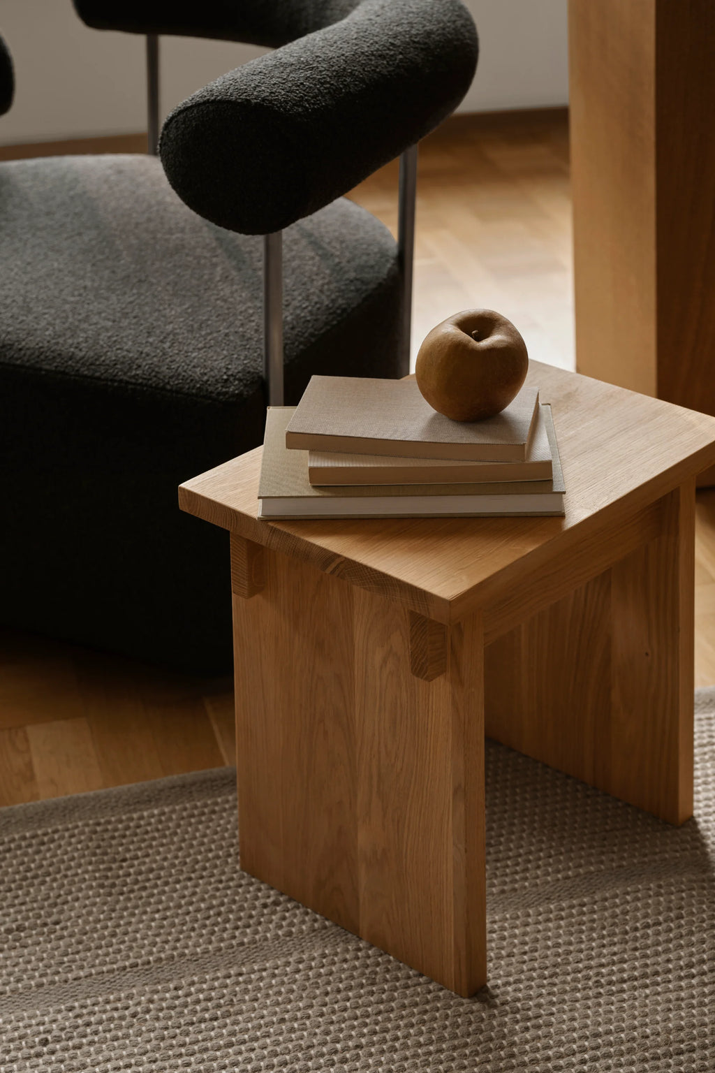 Kristina Dam Artisan Stool, a minimalist solid oak stool crafted from natural light oak wood with visible grain and a smooth finish. It features a thick rectangular top and sturdy block legs connected with exposed joinery details, embodying a clean, architectural form. This versatile piece is ideal as a Scandinavian side table, contemporary accent stool, or minimalist bedside table for Japandi-inspired interiors.