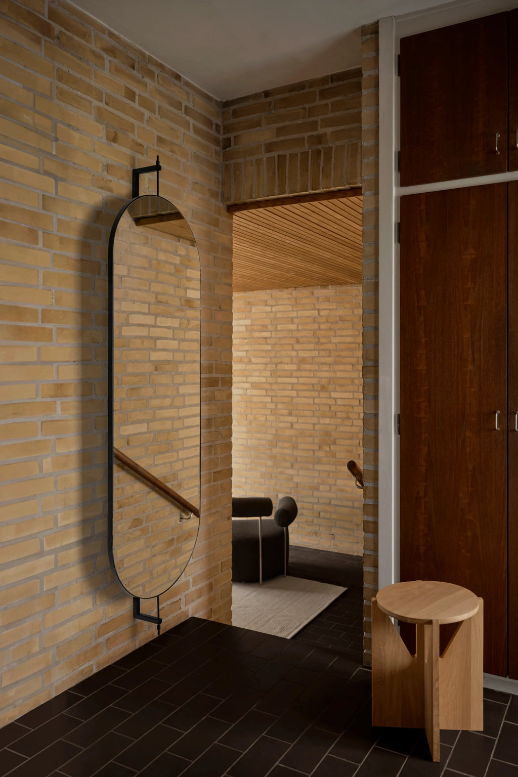 Kristina Dam Full Size Rotating Mirror, a sleek modern minimalist full-length mirror featuring an elongated oval shape and a matte black metal frame, designed to rotate freely on its wall-mounted bracket. This contemporary black metal wall mirror offers both functional reflection and a sculptural aesthetic, blending Scandinavian design with industrial chic elements. Ideal as a stylish entryway mirror, bedroom accent, or statement piece for modern living spaces.