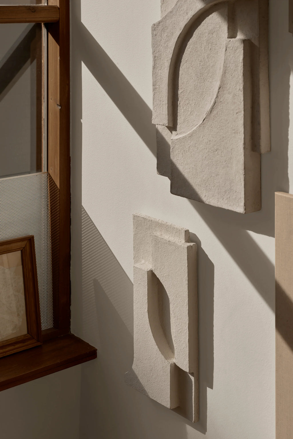 Kristina Dam Serif Relief S, a light beige concrete wall art piece featuring a textured, matte finish and an abstract brutalist relief sculpture with bold geometric and organic shapes. This contemporary wall panel offers a minimalist statement for modern living rooms, bedrooms, or gallery walls, creating an impactful focal point.