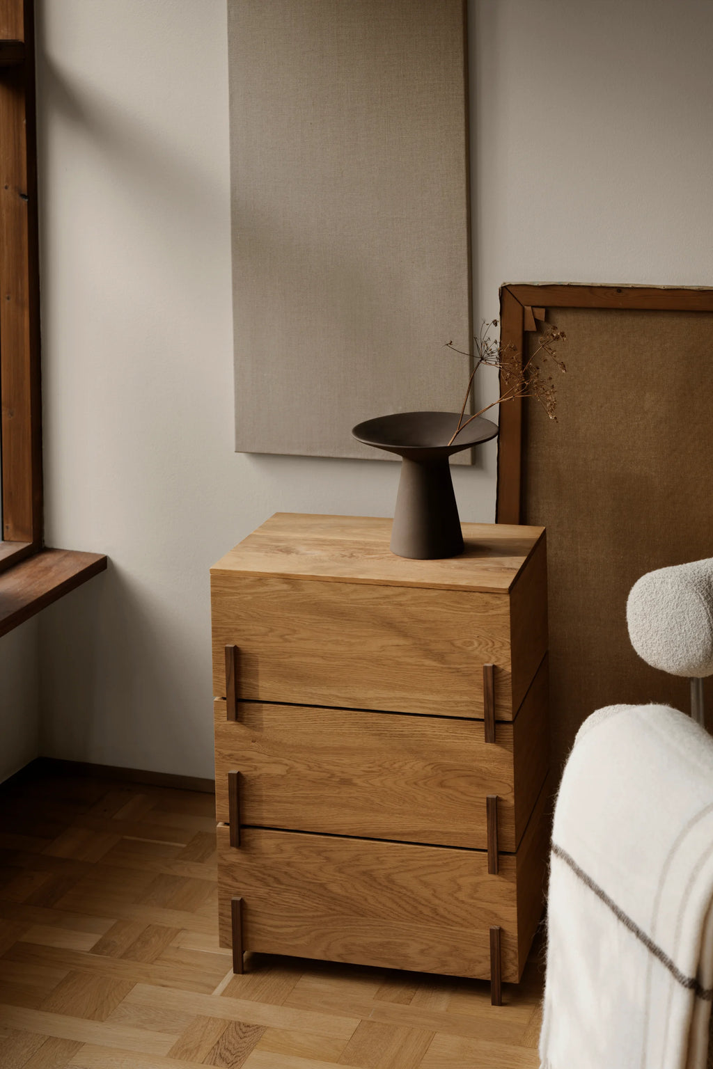 Kristina Dam Stack Storage Box - Set of 3, a modern minimalist storage unit crafted from natural solid oak wood with a visible grain, featuring three spacious drawers. Each drawer has integrated dark walnut wood pull handles and the unit stands on matching dark walnut feet, creating a sleek Scandinavian design. Ideal as a contemporary chest of drawers, bedside table, or stylish storage for living rooms and bedrooms.