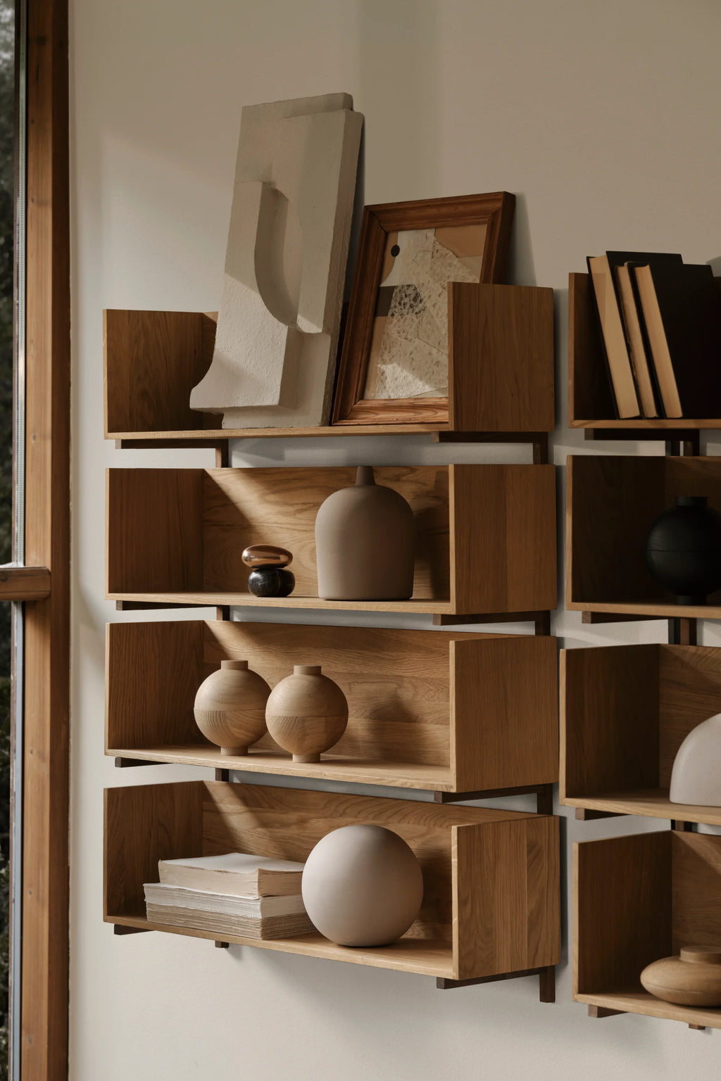 Kristina Dam Stack Wall Shelf, a modular modern minimalist shelving system crafted from natural solid oak wood with an open box design and subtle black metal wall mounts. This contemporary oak wall shelf is perfect for Scandinavian living room storage or organic modern home office display.