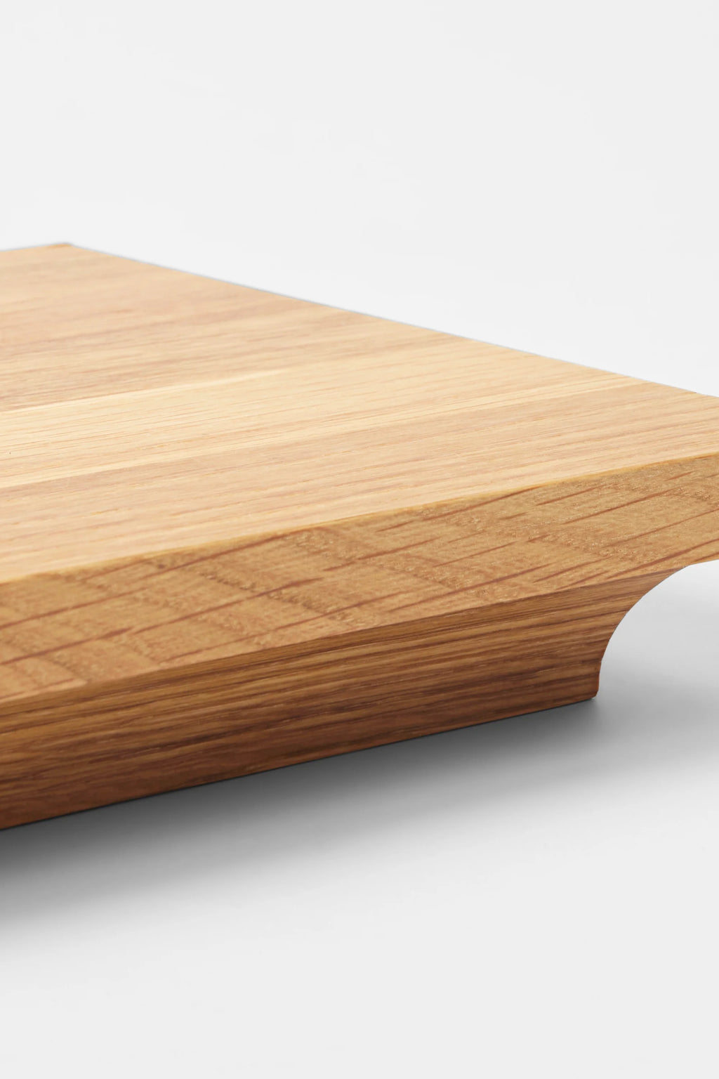 Kristina Dam Capital Podium, a thick, sculptural decorative tray crafted from solid natural oak wood, showcasing a warm light wood grain and a distinctive curved cut-out detail on one side. This modern minimalist wood podium is perfect for sophisticated shelf styling, as a coffee table display, or a unique serving board in Scandinavian or organic modern interiors.