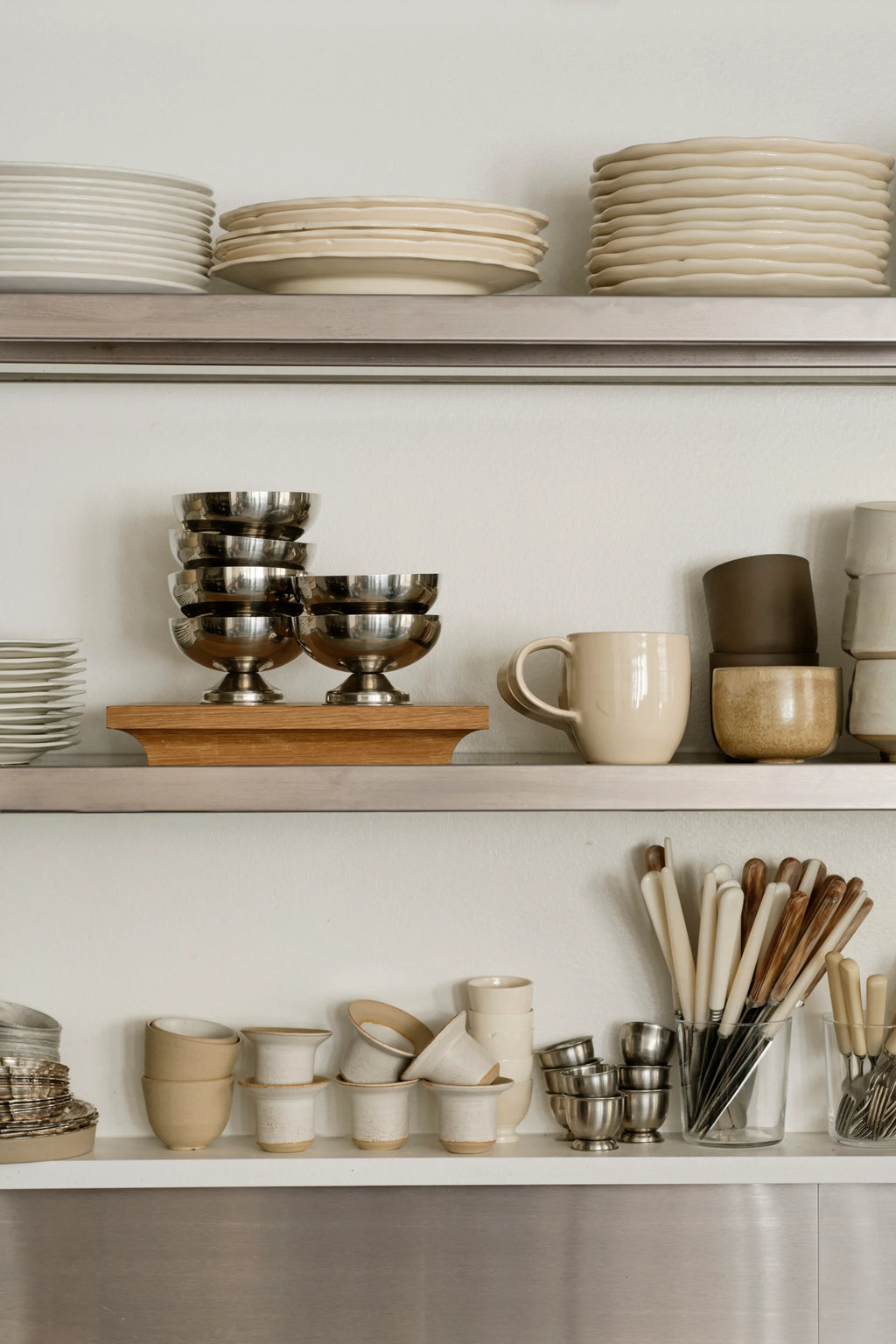 Kristina Dam Capital Podium, a solid oak decorative tray featuring a clean, modern minimalist design with a natural light wood finish and a uniquely curved edge. This versatile Scandinavian display stand is perfect for elegant shelf styling, creating a focal point on a kitchen counter, or serving as a refined dining table centerpiece.