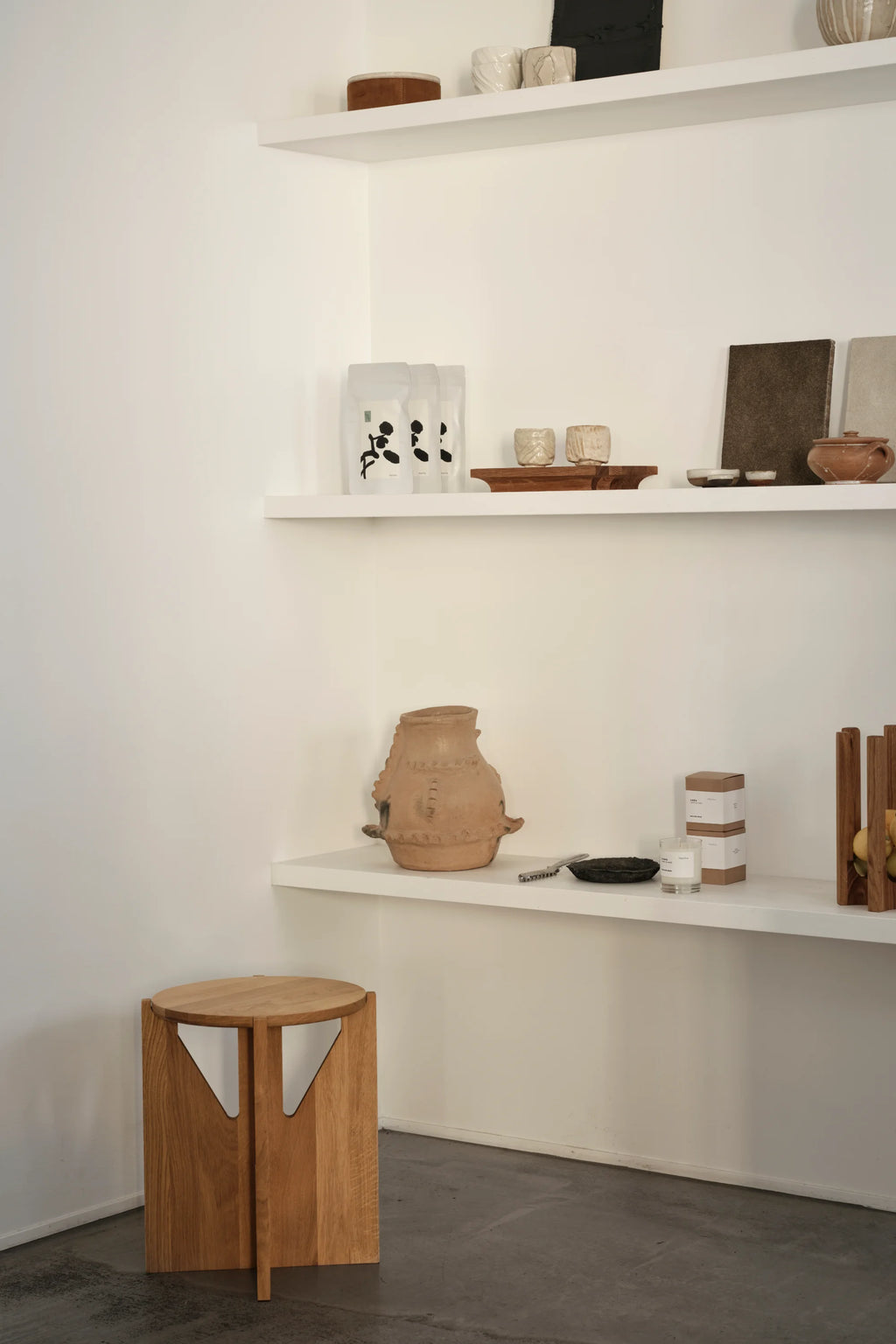 Kristina Dam Simple Stool, a modern minimalist solid oak stool featuring a round top and unique geometric cut-out legs that form a sculptural, cylindrical silhouette in a natural light wood finish. This versatile piece is perfect as a Scandinavian side table for living rooms, a contemporary bedside table, or an entryway accent.