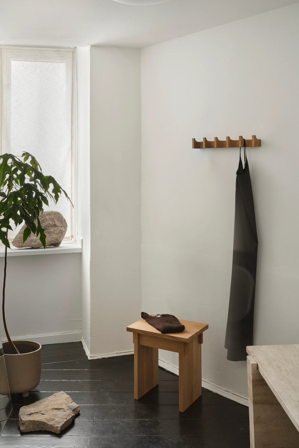 Kristina Dam Long Column Coat Rack, a modern minimalist wall hanger crafted from solid oak with a natural light wood finish. This Scandinavian-inspired coat rack features five sculptural, upward-curving hooks on a rectangular base, offering elegant wall storage. Perfect for a functional and stylish entryway, hallway, or bedroom accent in organic modern interiors.