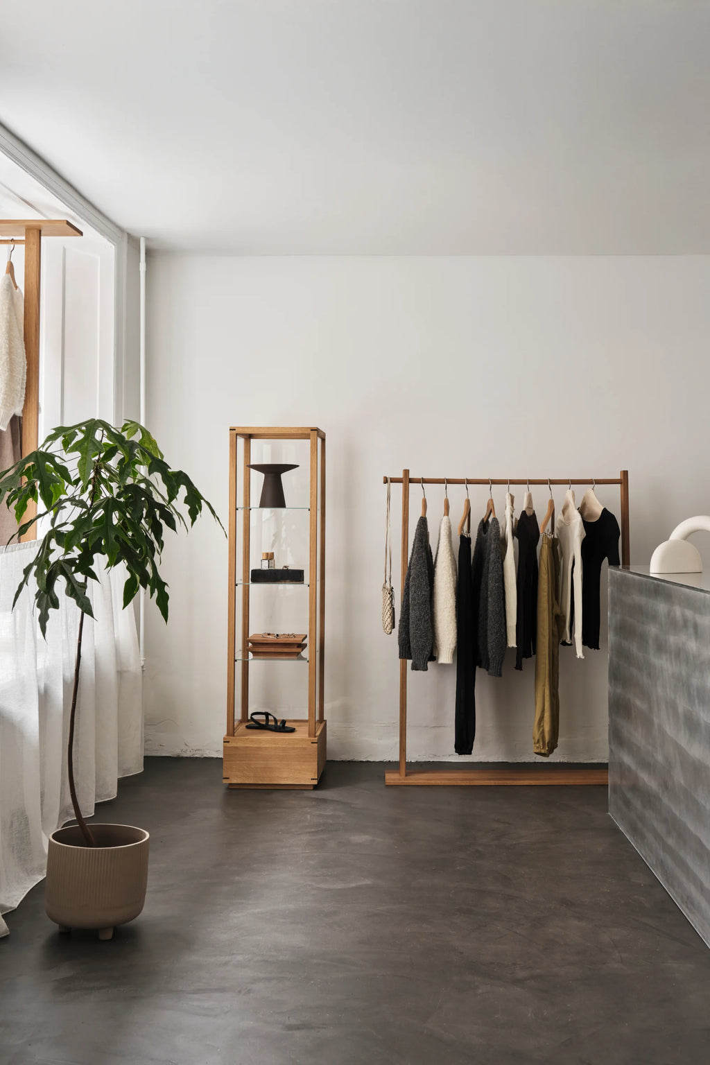 Kristina Dam Japanese Cabinet M, a tall, slender solid oak display cabinet crafted with a natural wood finish and clear glass shelves, reflecting Japanese minimalist and Scandinavian design principles.