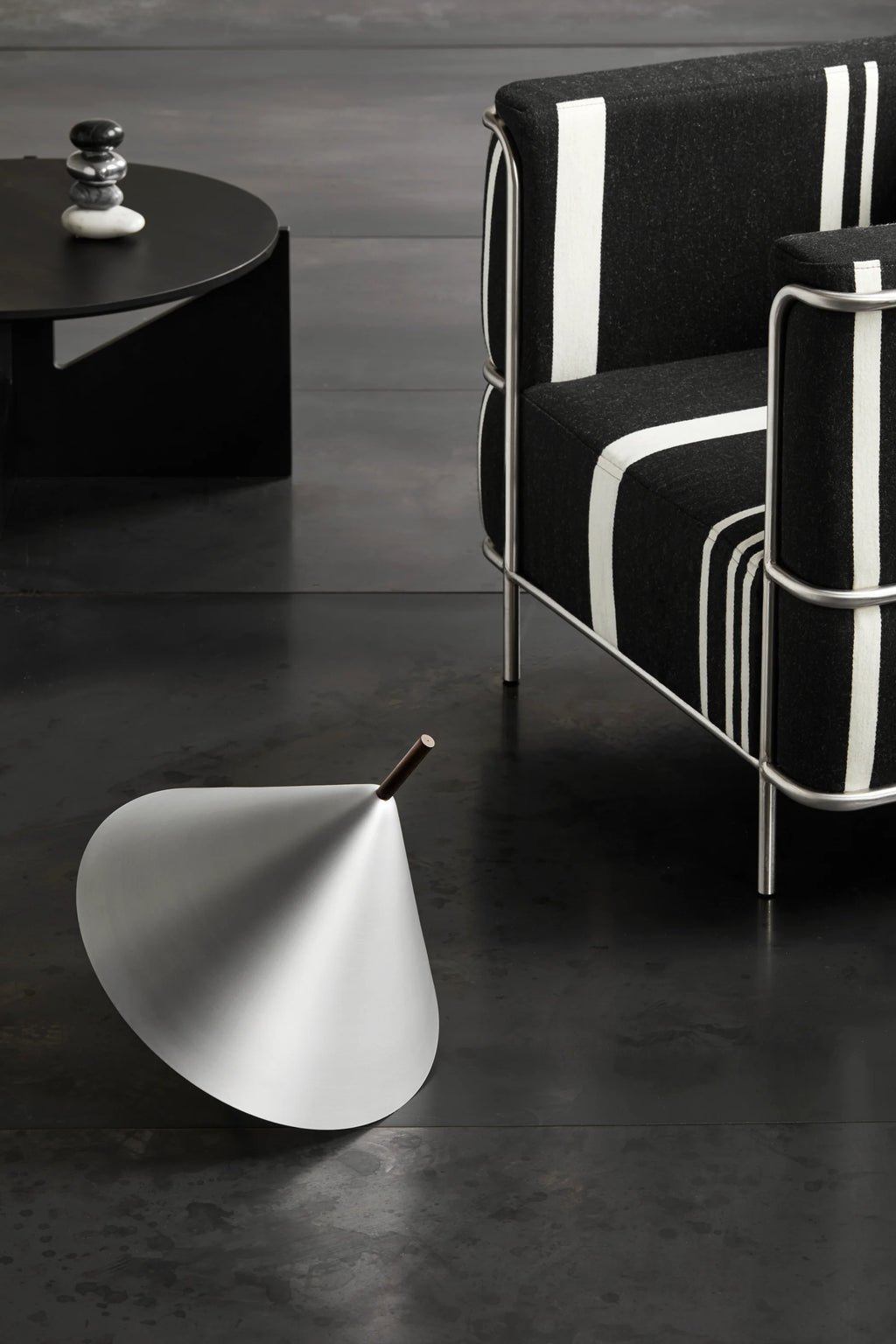 Kristina Dam Simple XL Coffee Table, a bold matte black metal coffee table featuring a striking round tabletop and sturdy geometric base, embodying a modern minimalist design. Crafted from durable black powder-coated steel, its clean lines and robust form make it ideal for contemporary living rooms, industrial chic spaces, or brutalist-inspired interiors.
