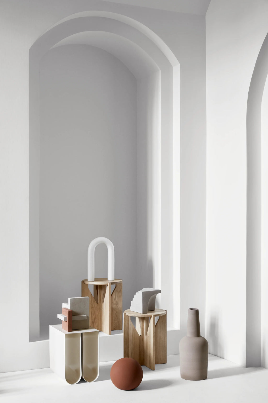 Kristina Dam Curved Side Table, a sleek modern minimalist accent table with a smooth, matte white finish and a distinctive U-shaped silhouette, featuring two inward-curving panels that create a.