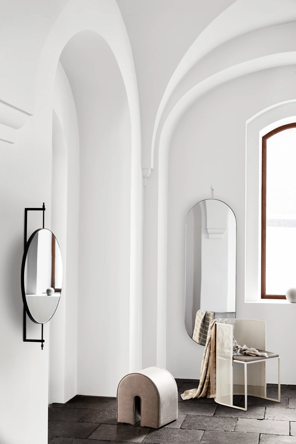 Kristina Dam Rotating Mirror, a sleek modern minimalist oval mirror featuring a matte black metal frame and an innovative wall-mounted design that allows for smooth rotation. This functional Scandinavian-inspired piece offers a contemporary touch with its clean lines and refined aesthetic. Ideal as a decorative mirror for entryways, living rooms, or bedrooms in modern homes.