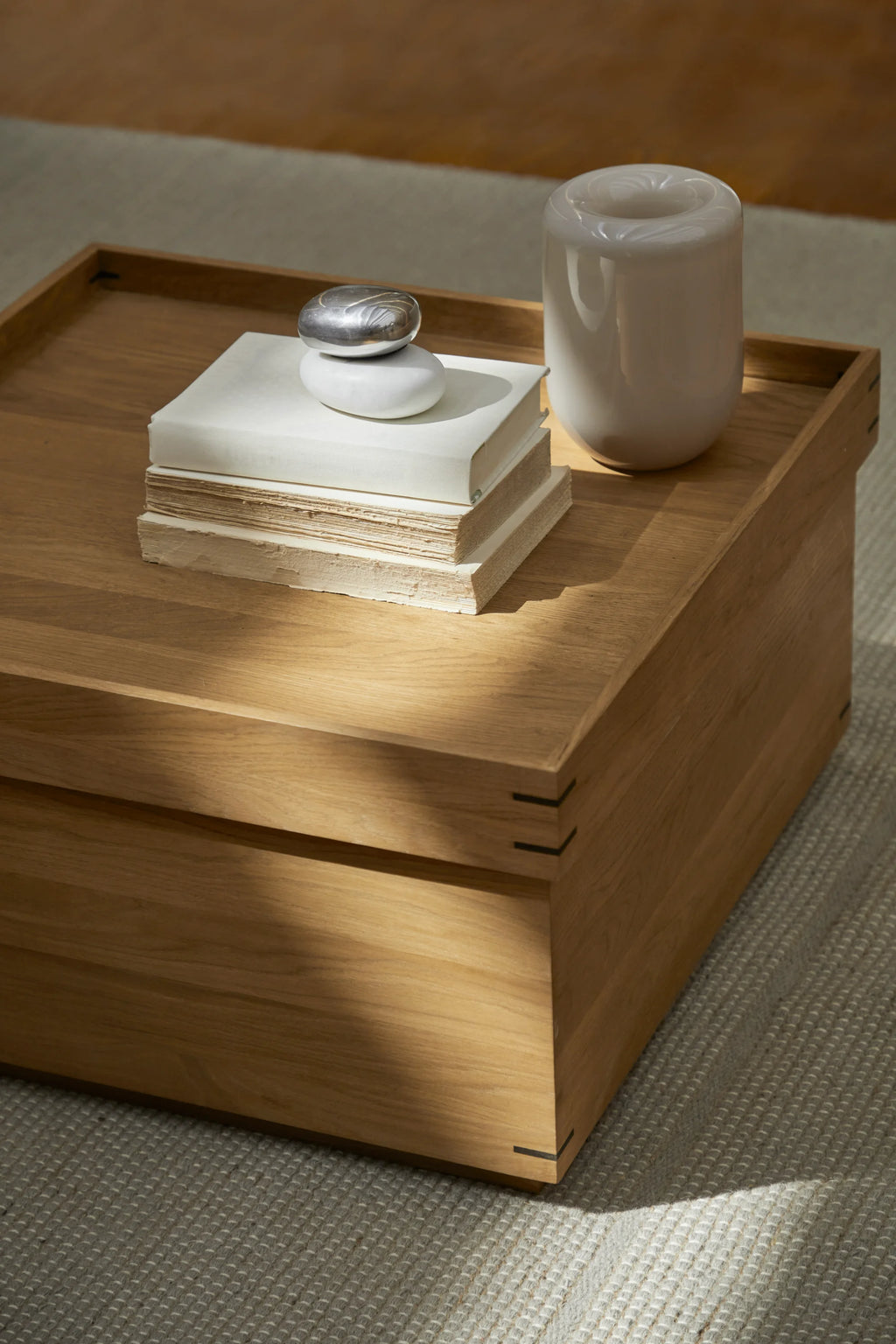 Kristina Dam Japanese Tray Table, a modern minimalist square coffee table crafted from beautiful light solid oak wood with a distinctive tray-style top and elegant black metal joinery details. This Scandinavian-inspired design offers hidden storage and clean lines, making it a perfect Japandi living room coffee table or stylish side table for contemporary interiors.