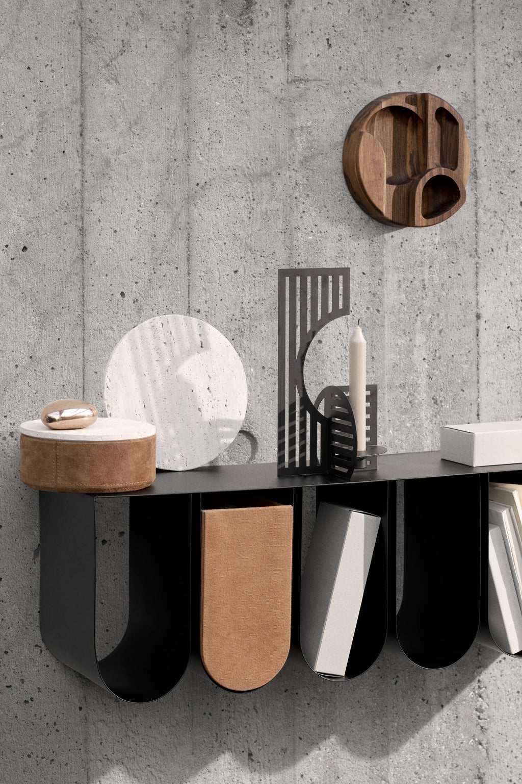 Kristina Dam Curved Wall Shelf, a sleek matte black metal wall shelf with a modern minimalist design, featuring a rectangular top surface and three distinctive curved, U-shaped compartments for storage and display. The industrial chic aesthetic is highlighted by its clean lines and smooth finish. This contemporary Scandinavian wall shelf is perfect for entryway organization, living room decor, or stylish home office storage.