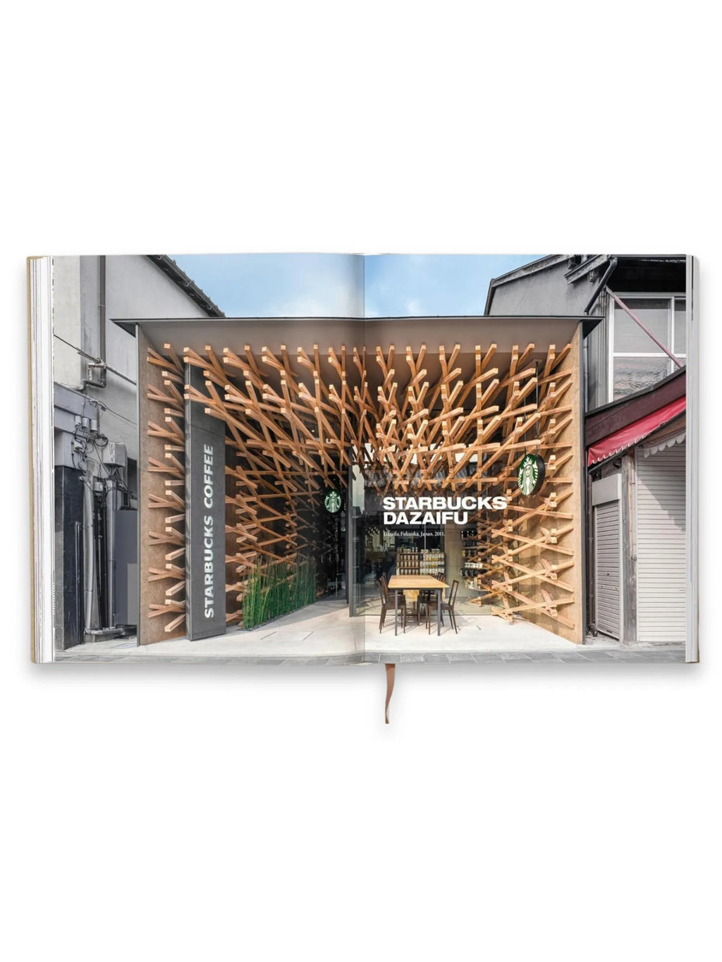 Book Kuma. Complete Works 1988–Today, open to a full-color page showcasing a unique Starbucks Dazaifu cafe with an intricate, modern wooden lattice facade. This architectural book is an inspiring read for design students and architecture enthusiasts.