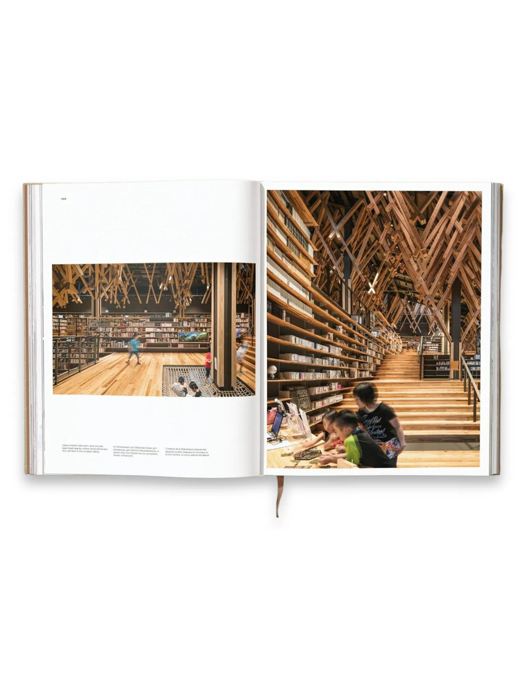 Book Kuma. Complete Works 1988–Today, open pages displaying vibrant, detailed photographs of modern architectural library interiors with intricate wooden lattice ceilings and expansive bookshelves. This essential architecture book is ideal for students, professionals, and enthusiasts interested in contemporary design and visionary structures.
