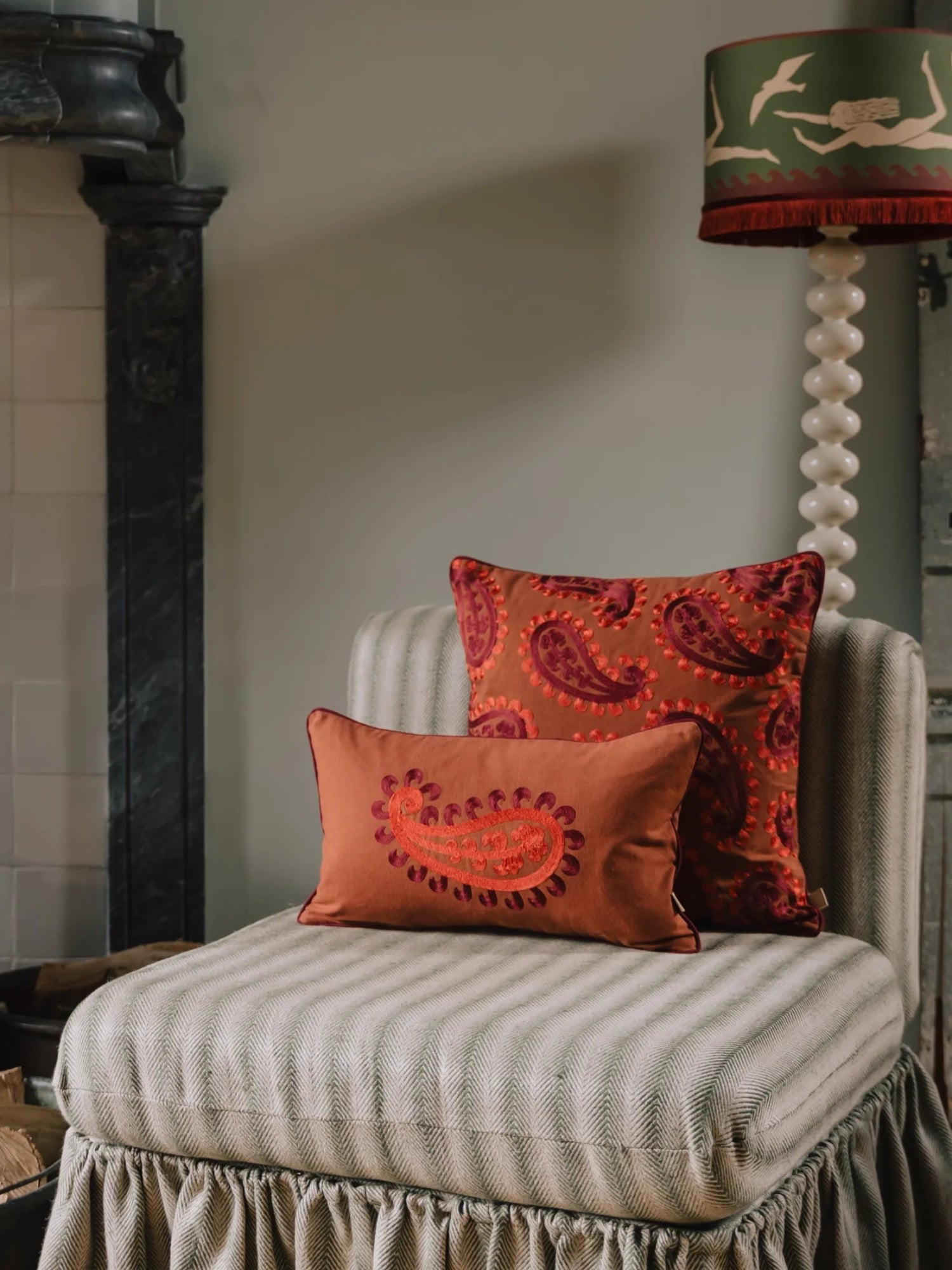 Palais Double Sided Siena Throw Pillow, a rich burnt orange velvet throw pillow featuring intricate deep red paisley embroidery and matching piping, offering a plush texture and vibrant pattern.