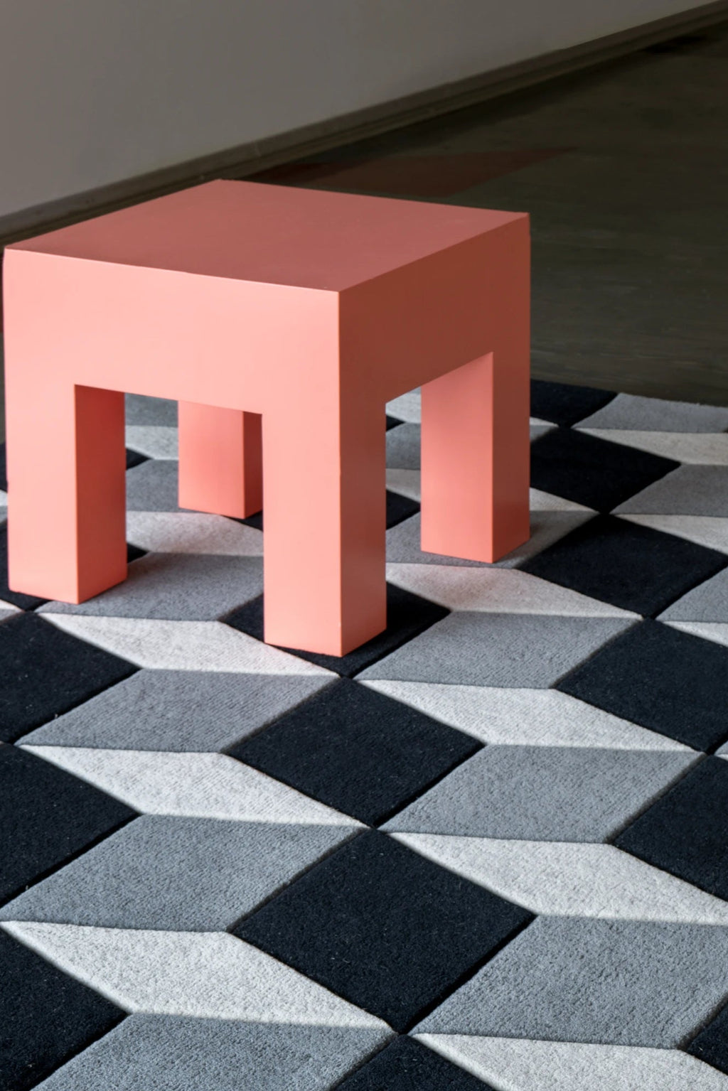 Layered Illusion Wool Rug, a modern geometric area rug with a 3D cube pattern in shades of black, dark grey, and light grey wool. Perfect for adding a contemporary accent to any living room or bedr...
