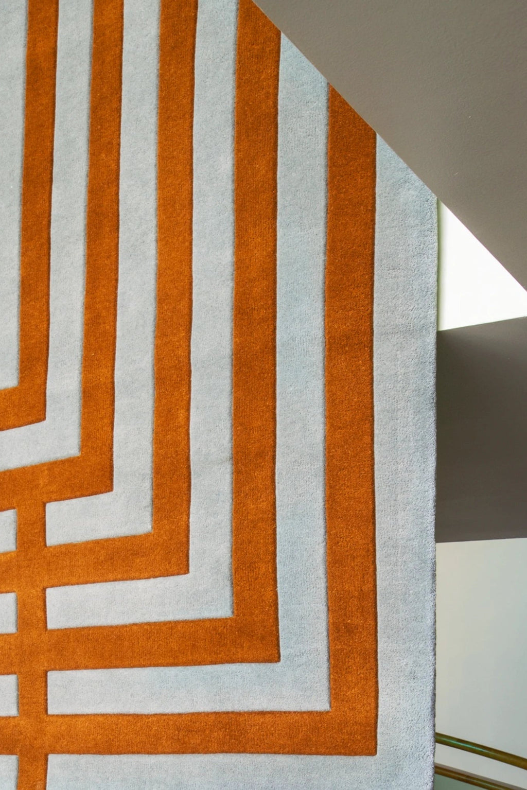 Layered Letters Wool Rug, a modern geometric area rug featuring bold orange stripes and light gray negative space forming an abstract letter pattern. Perfect for adding a vibrant, contemporary touc...
