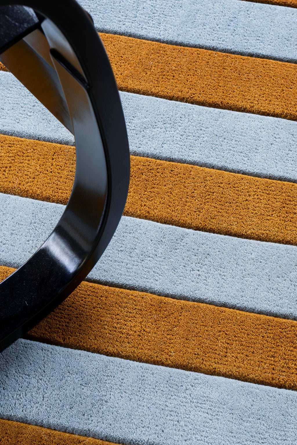 Layered Letters Wool Rug, a textured modern area rug featuring bold horizontal stripes in light blue and warm orange-brown. Perfect for adding a colorful, cozy touch to any living space or bedroom.