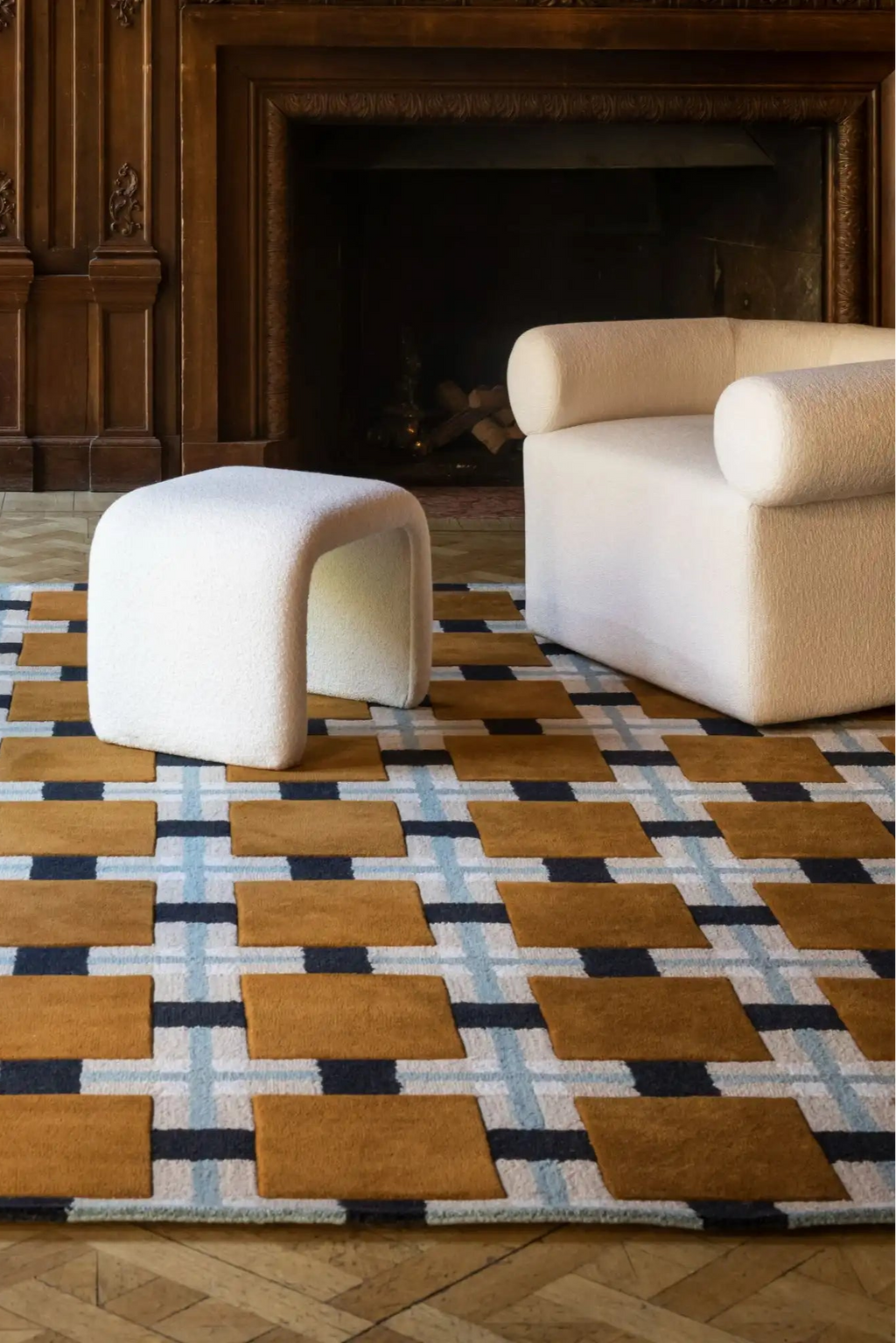 Layered Ochre Fields Wool Rug, a luxurious modern area rug featuring a geometric plaid pattern in shades of ochre, black, and light blue. Perfect for adding warmth and sophisticated style to any li...