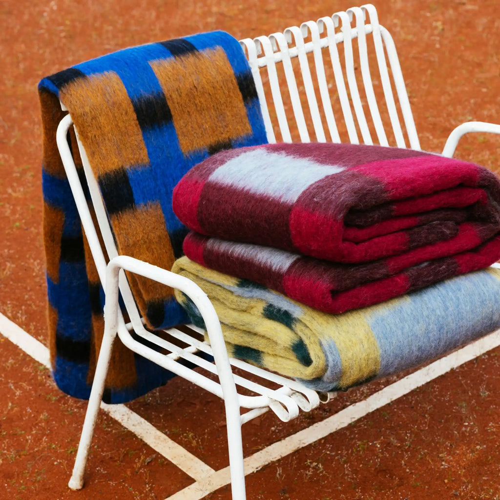Layered Fall Foliage Oversized Blanket. A cozy, colorful plaid mohair throw with blocks of red, blue, yellow, and black. Perfect for adding warmth and style to any living space or bedroom.