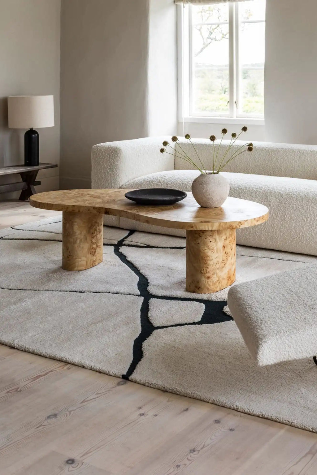 Layered Gute Wool Rug, a light beige and black abstract patterned plush wool area rug with organic shapes. Perfect for adding modern texture and warmth to a living room or bedroom.
