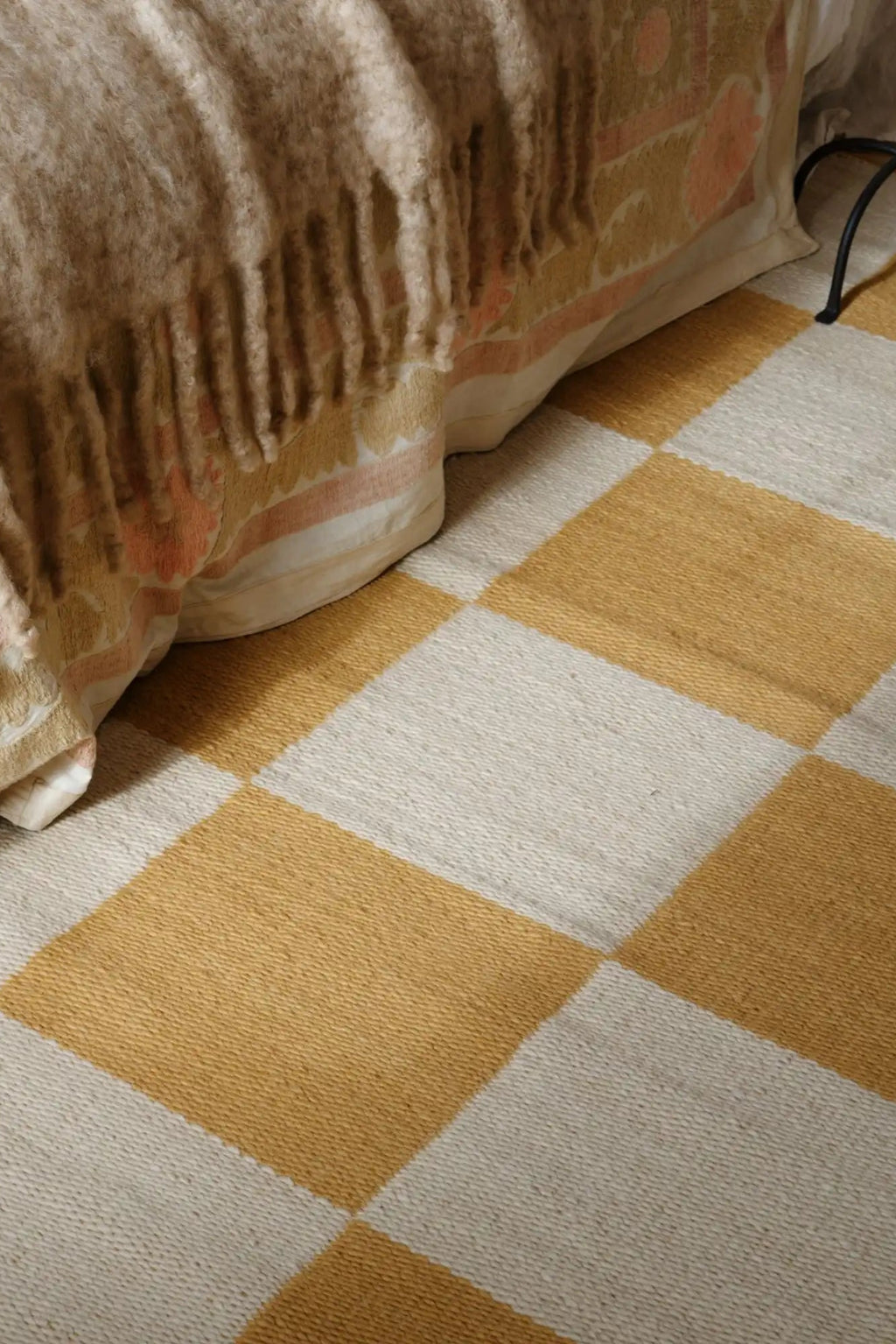 Layered Chess Wool Rug, a luxurious hand-tufted natural wool area rug featuring a striking mustard yellow and cream checkerboard pattern. Perfect for adding a modern, cozy accent to any living room...