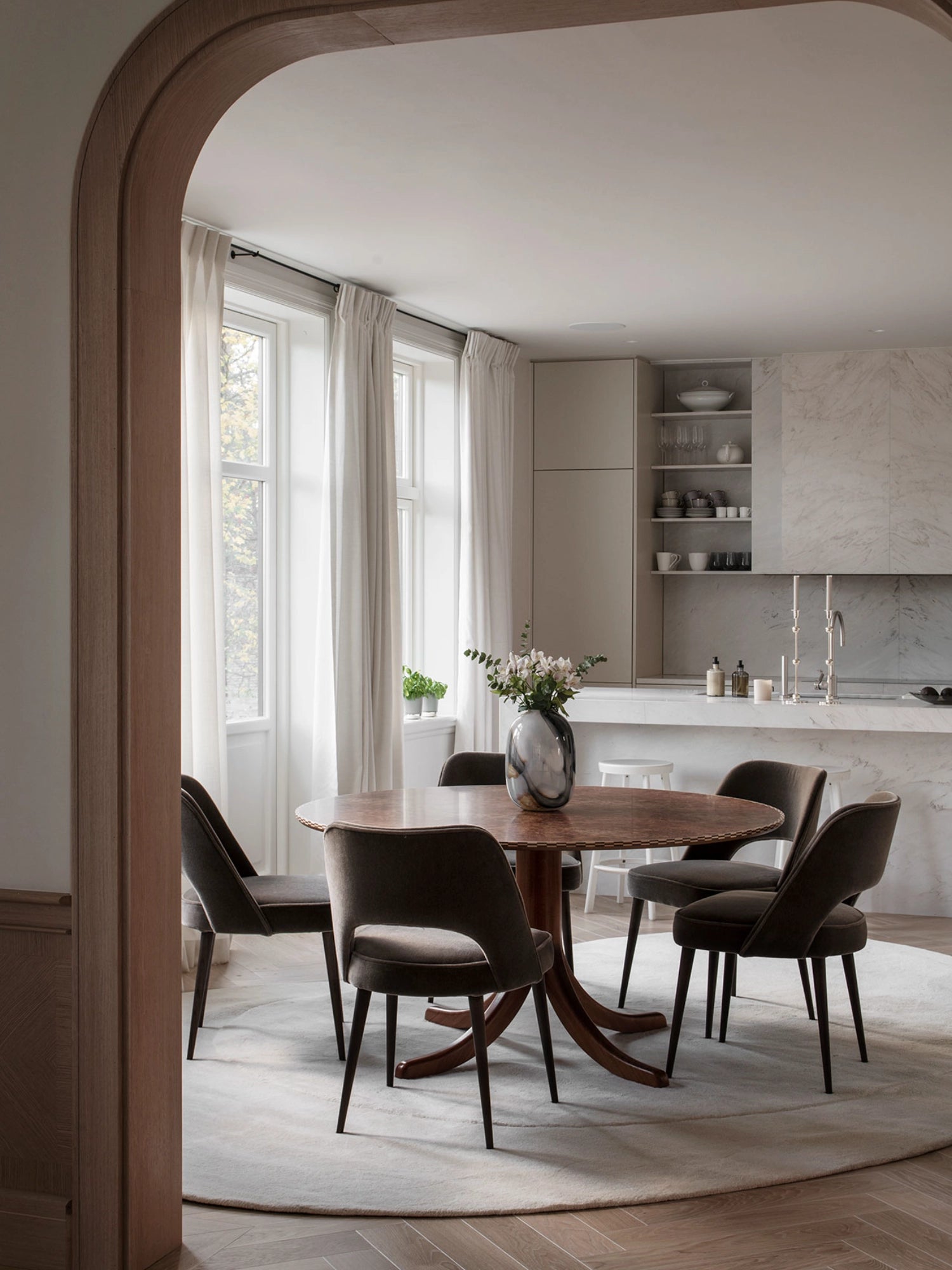 Layered Residue Wool Rug, a luxurious round wool area rug in a soft, light greige tone with a plush, hand-tufted texture, creating a serene and organic foundation. This minimalist Scandinavian rug is ideal for cozy dining room settings or adding understated elegance to a contemporary living room.