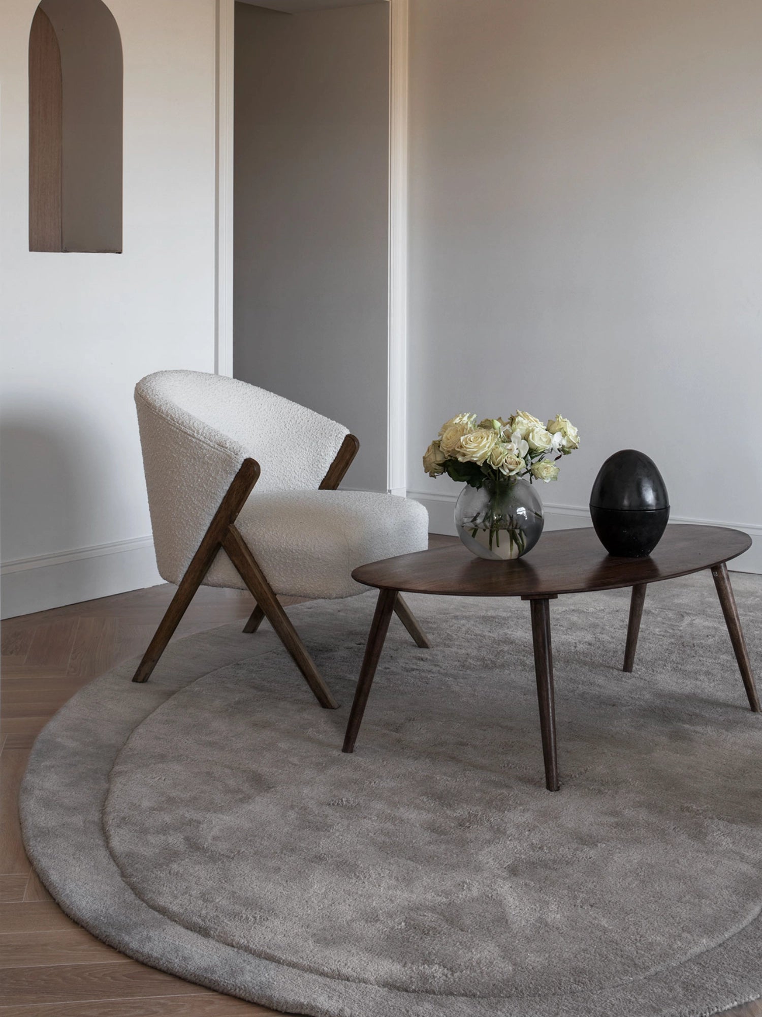 Layered Residue Wool Rug, a soft grey round wool rug featuring a plush, high-pile texture and a subtle raised border detail, creating an organic, layered effect. This modern minimalist area rug is perfect for adding warmth and texture to Scandinavian living rooms, cozy bedrooms, or contemporary entryways.